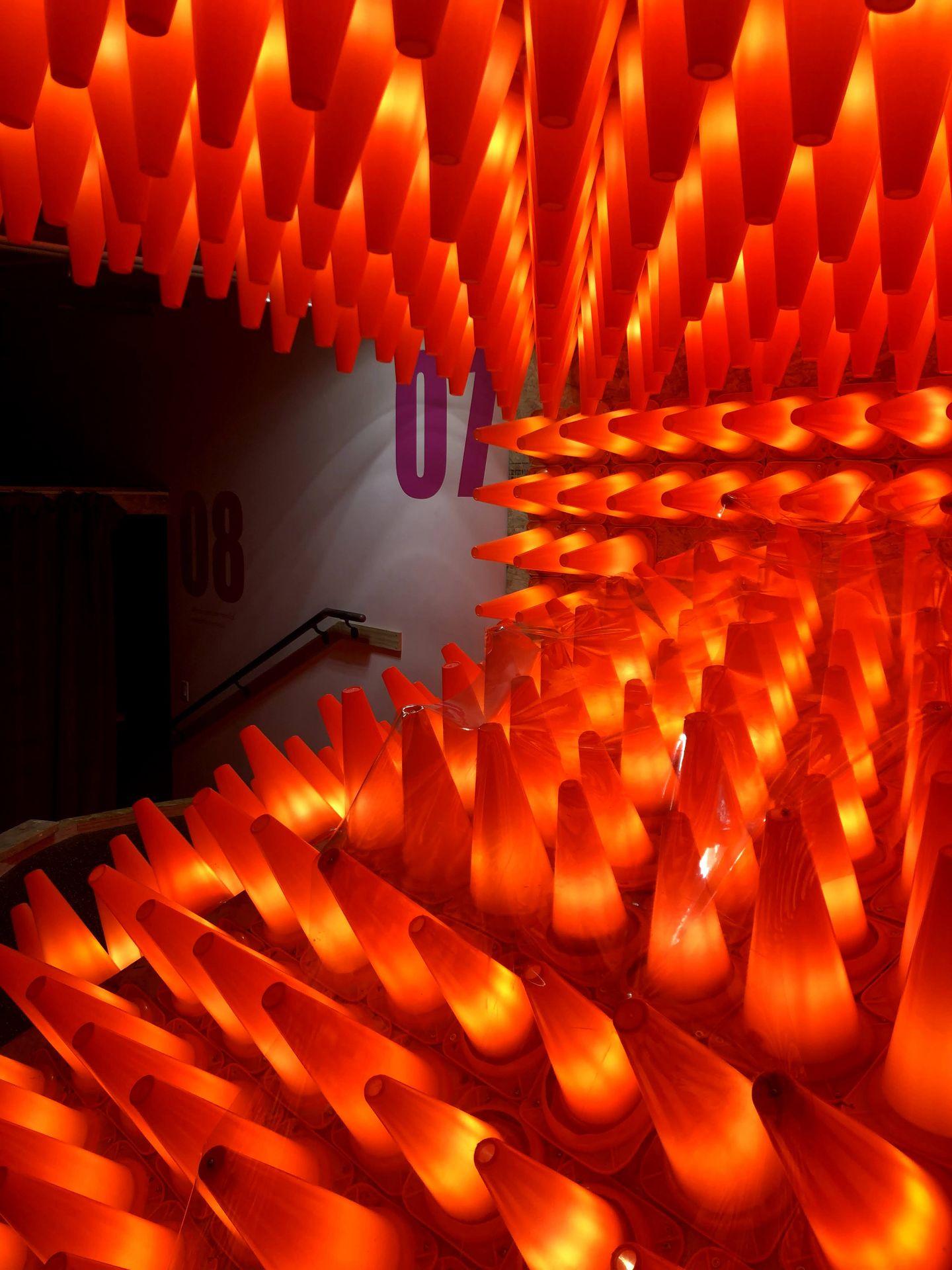 A display of lit-up orange traffic cones, one of hte mini golf holes.