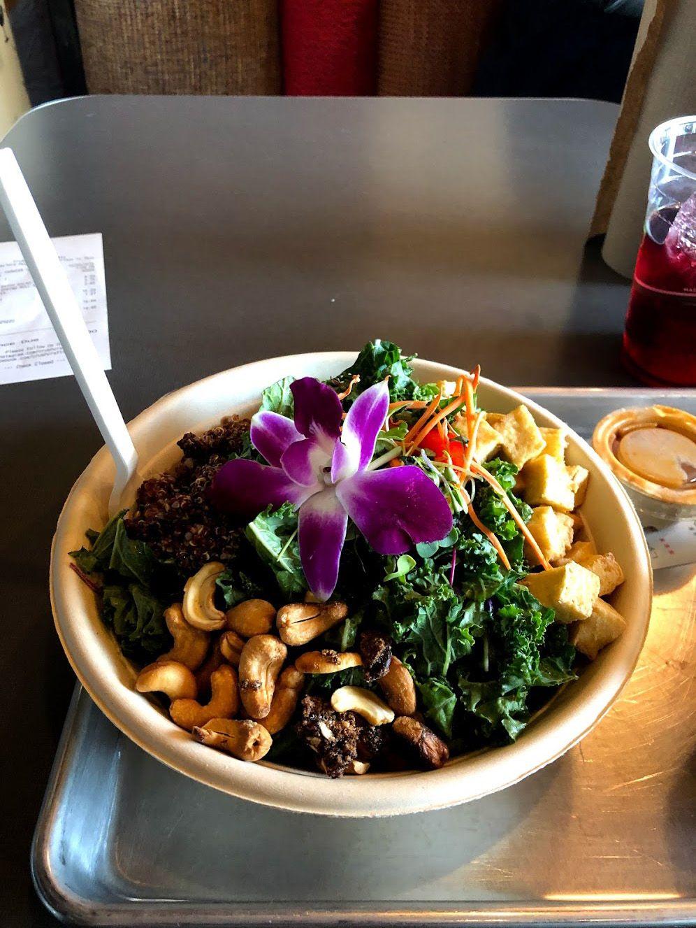 A bowl with kale, cashews, tofu and a flower from Crush Craft Thai Eats.