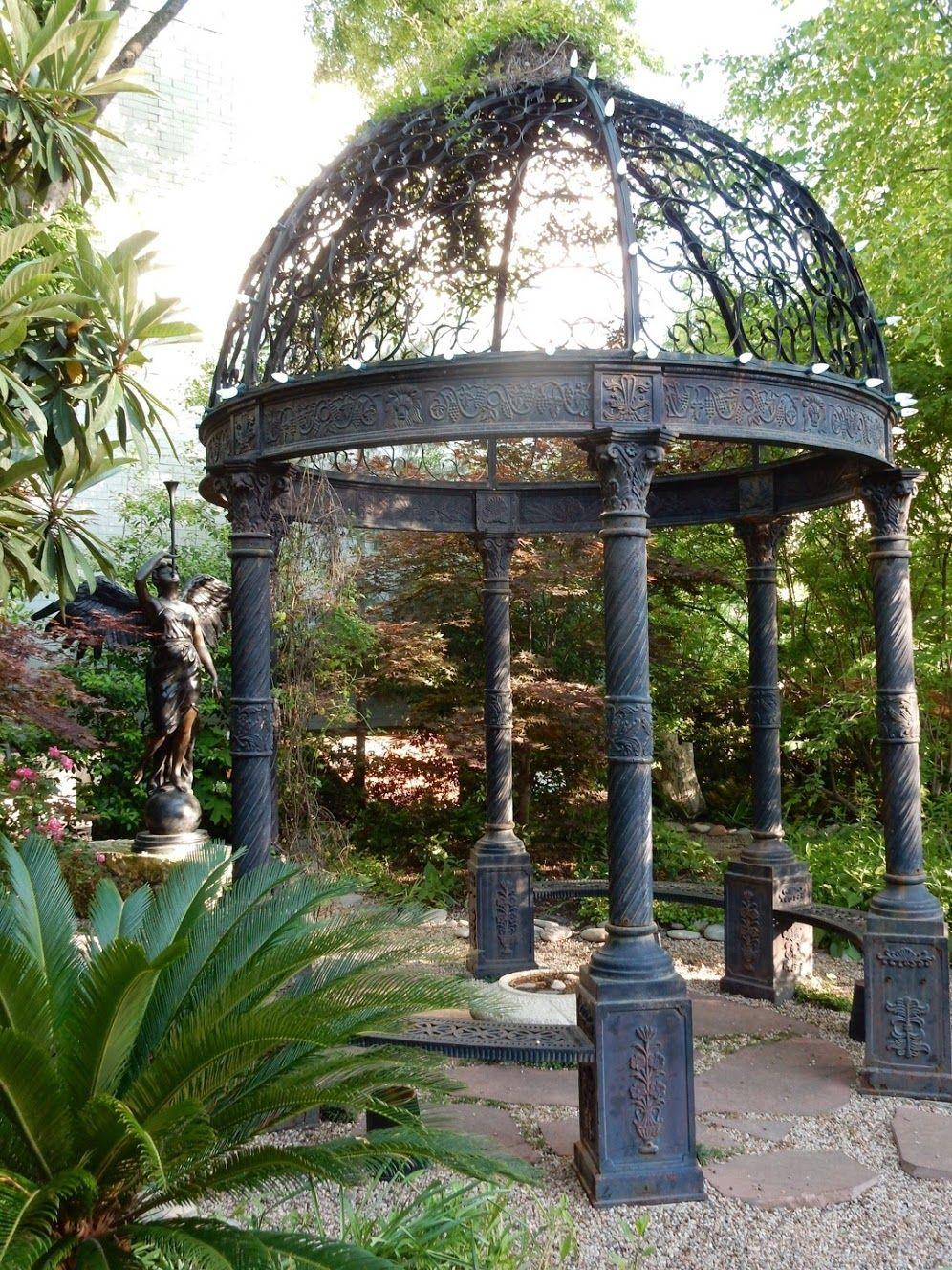 A gazebo with an angel statue next to it.
