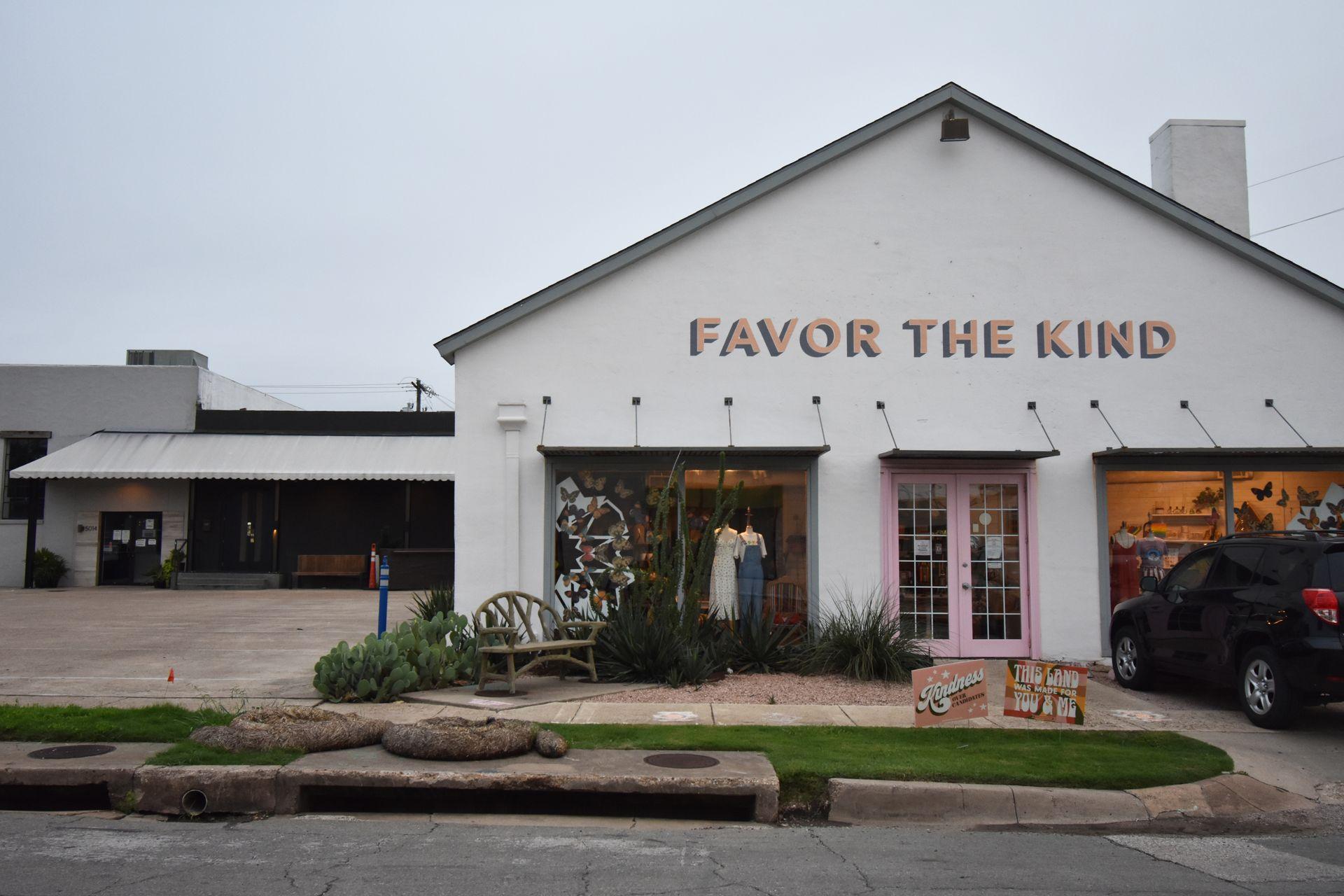 The exterior of Favor the Kind. The building is white with the words "Favor the Kind" painted in pink.