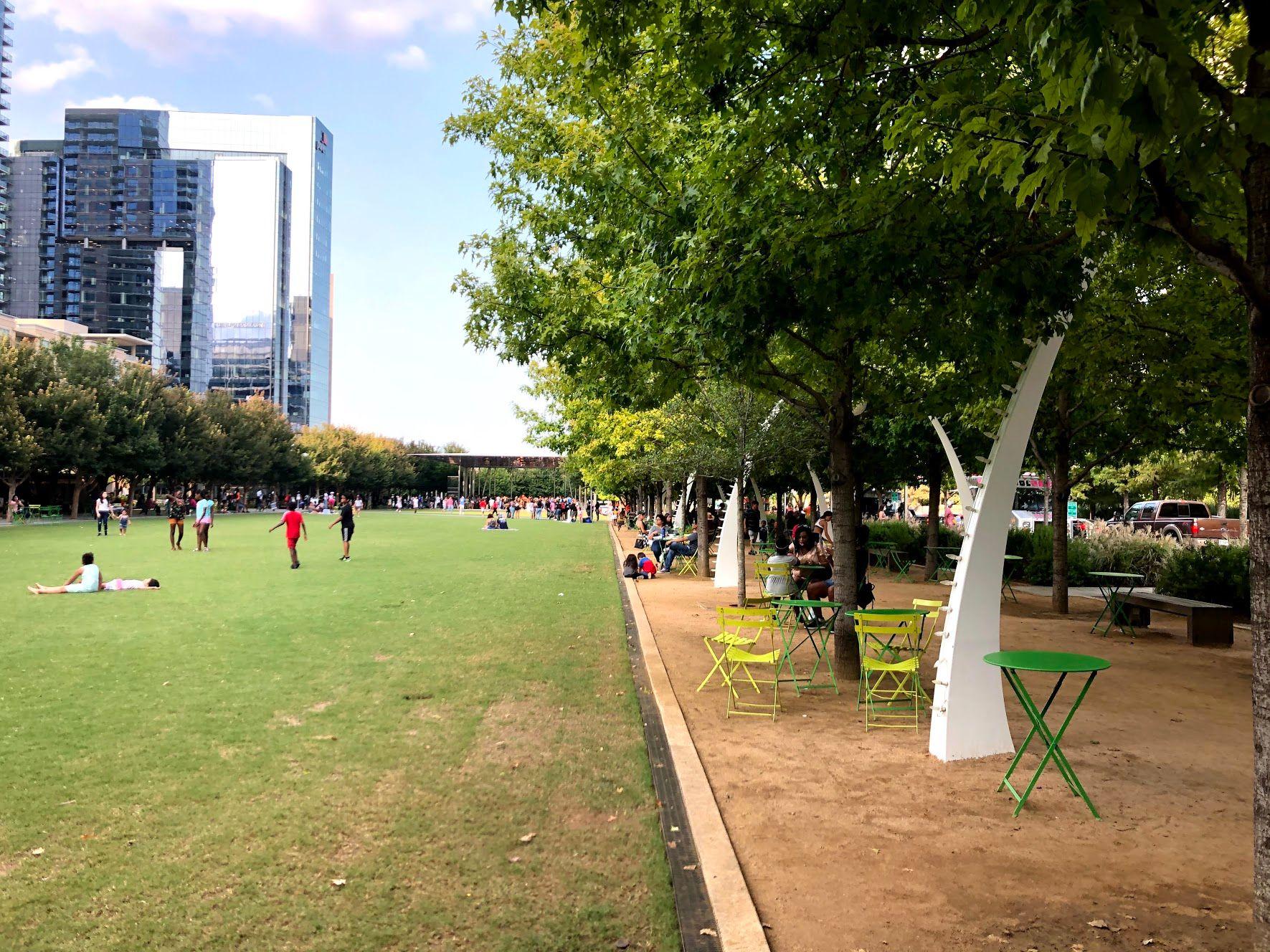The lawn area and a shaded area with picnic tables in Klyde Warren Park