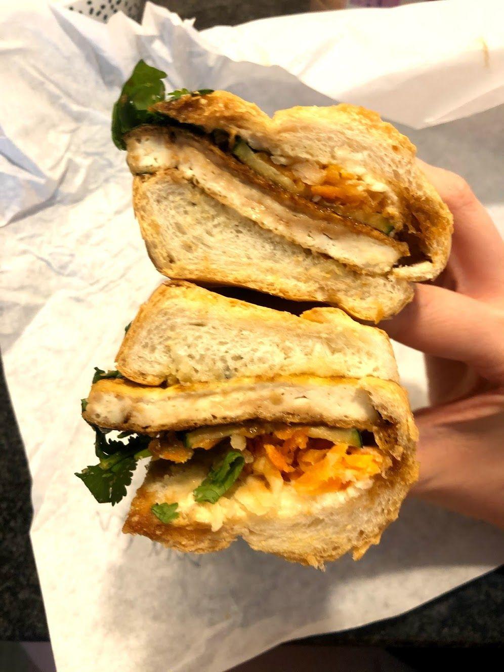 Holding up a Bahn Mi sandwich from Sandwich Hag.