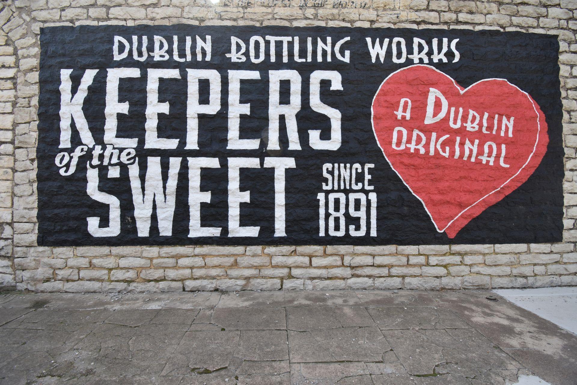 A mural in downtown Dublin that reads "Dublin Bottling Works, Keepers of the Sweet Since 1891, A Dublin Original"
