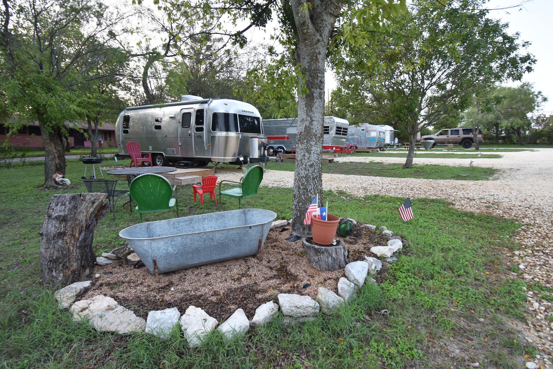 A row of airstreams and trailers at the Off the Vine RV Park. In the foreground, there is a vintage bathtub decoration.