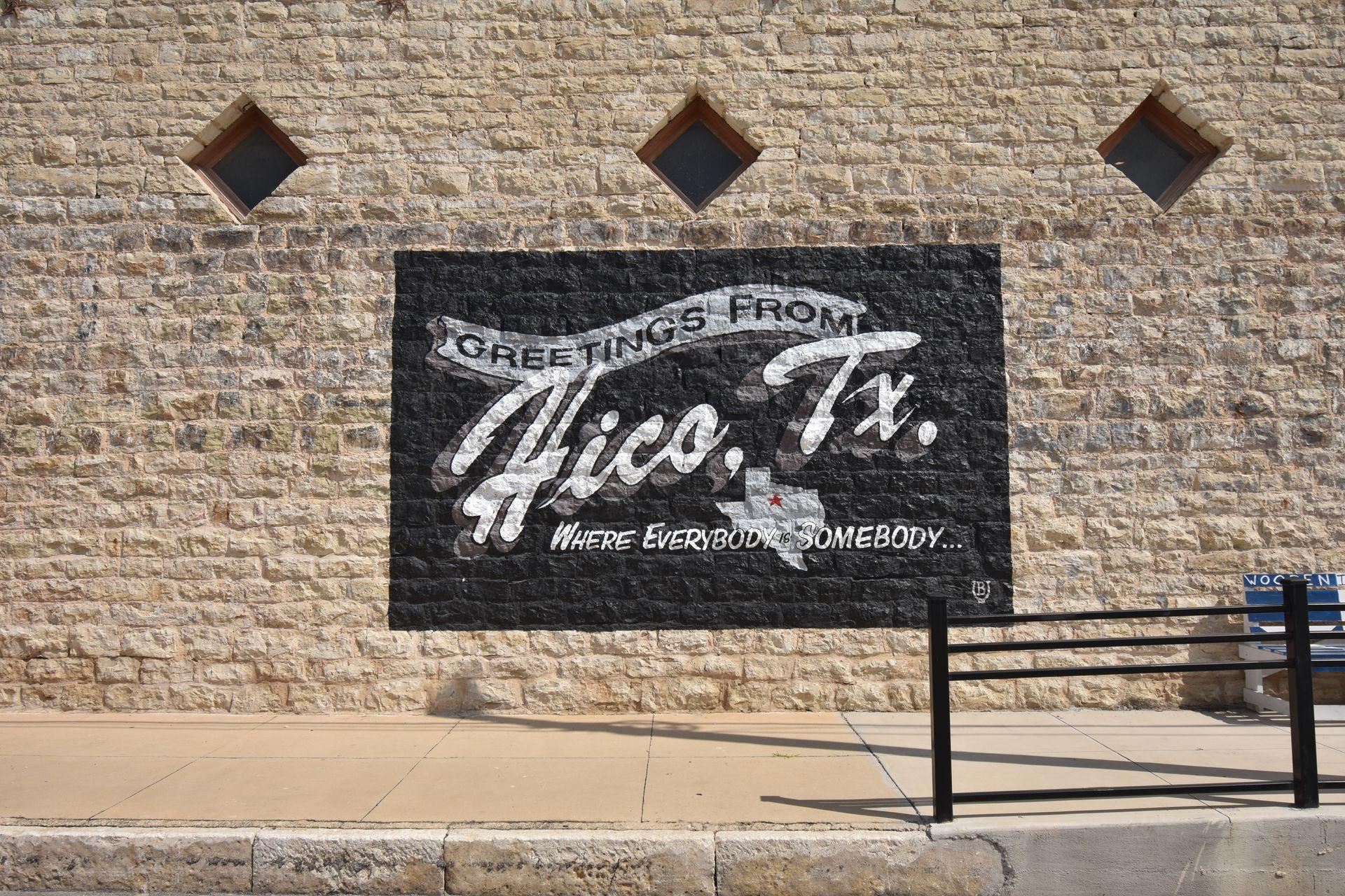 A mural that reads "Greetings from Hico, TX, Where Everybody in Someday"