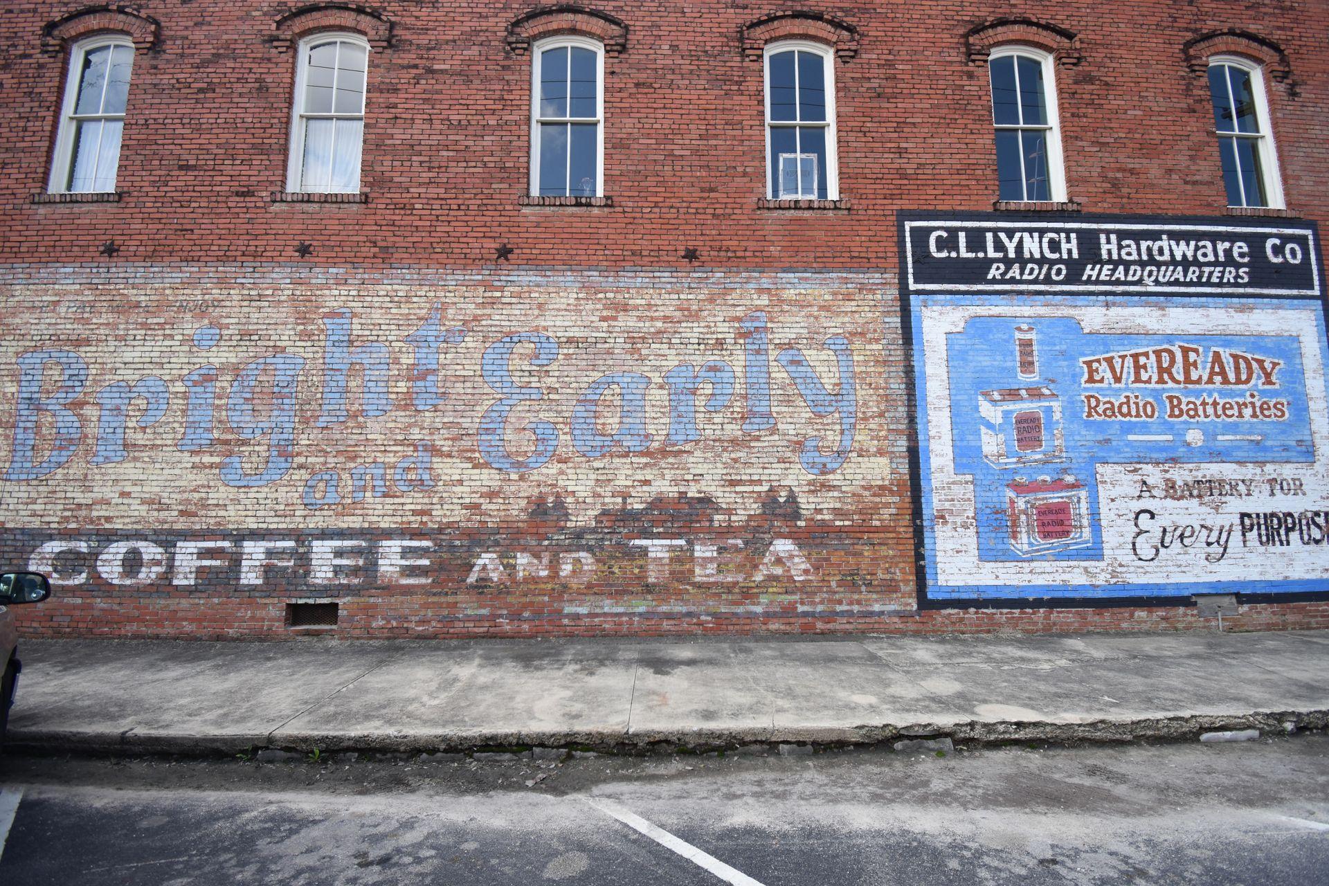 Faded murals on a brick building in downtown Hico. One reads "Bright and Early Coffee and Tea"