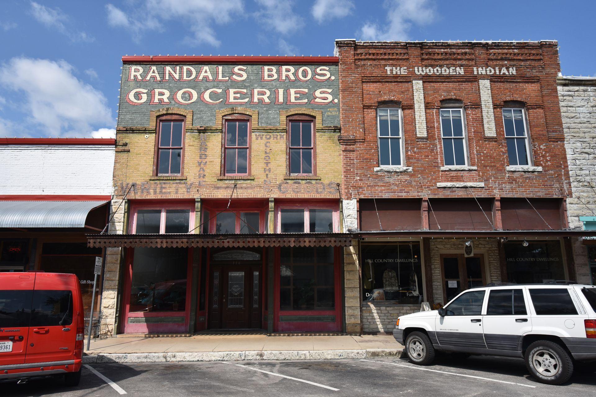 An exterior of two buildings in Hico that are brick and vintage looking. One reads "Randal Bros Groceries"