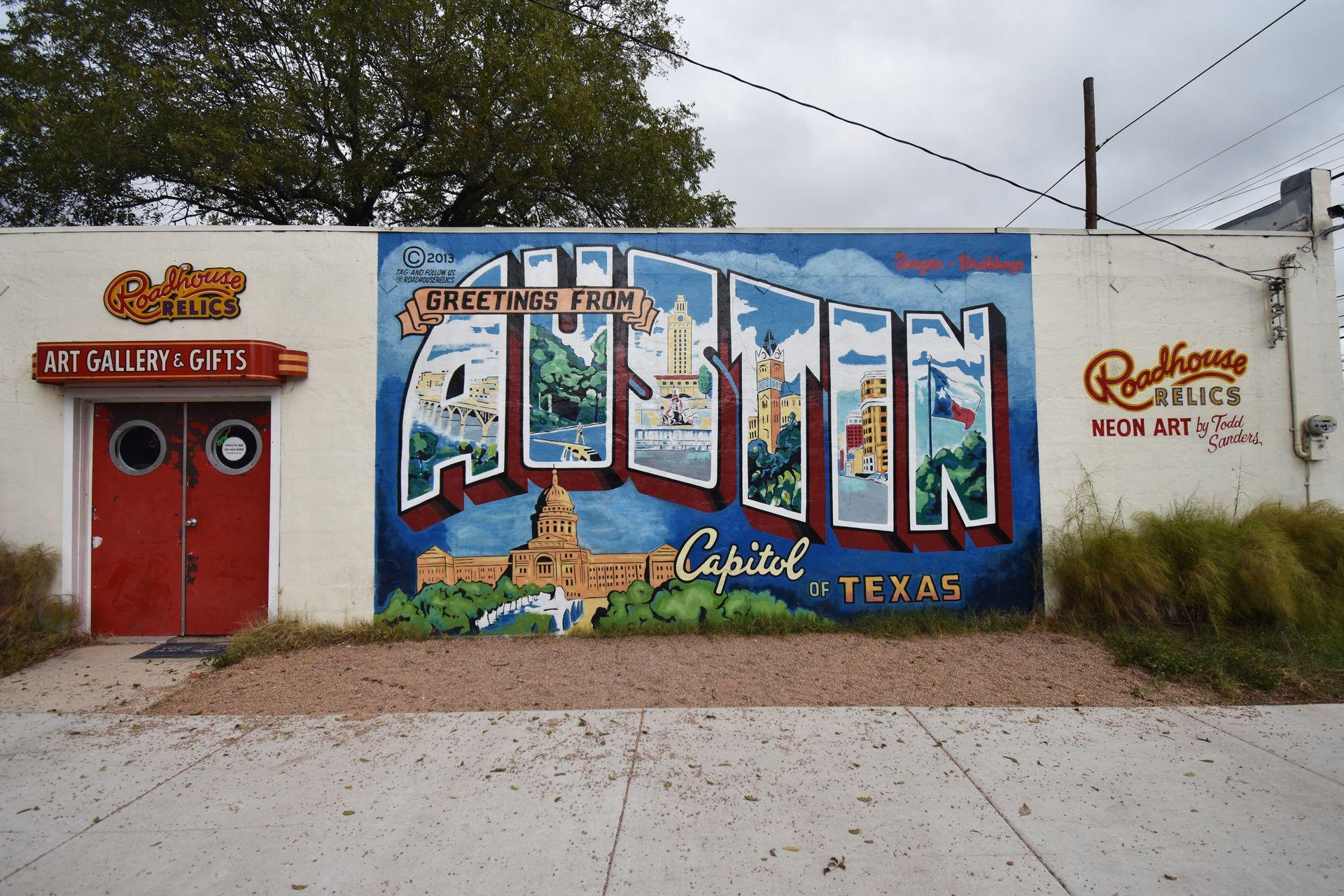 A colorful mural that reads "Greetings from Austin" on the side of Roadside Relics
