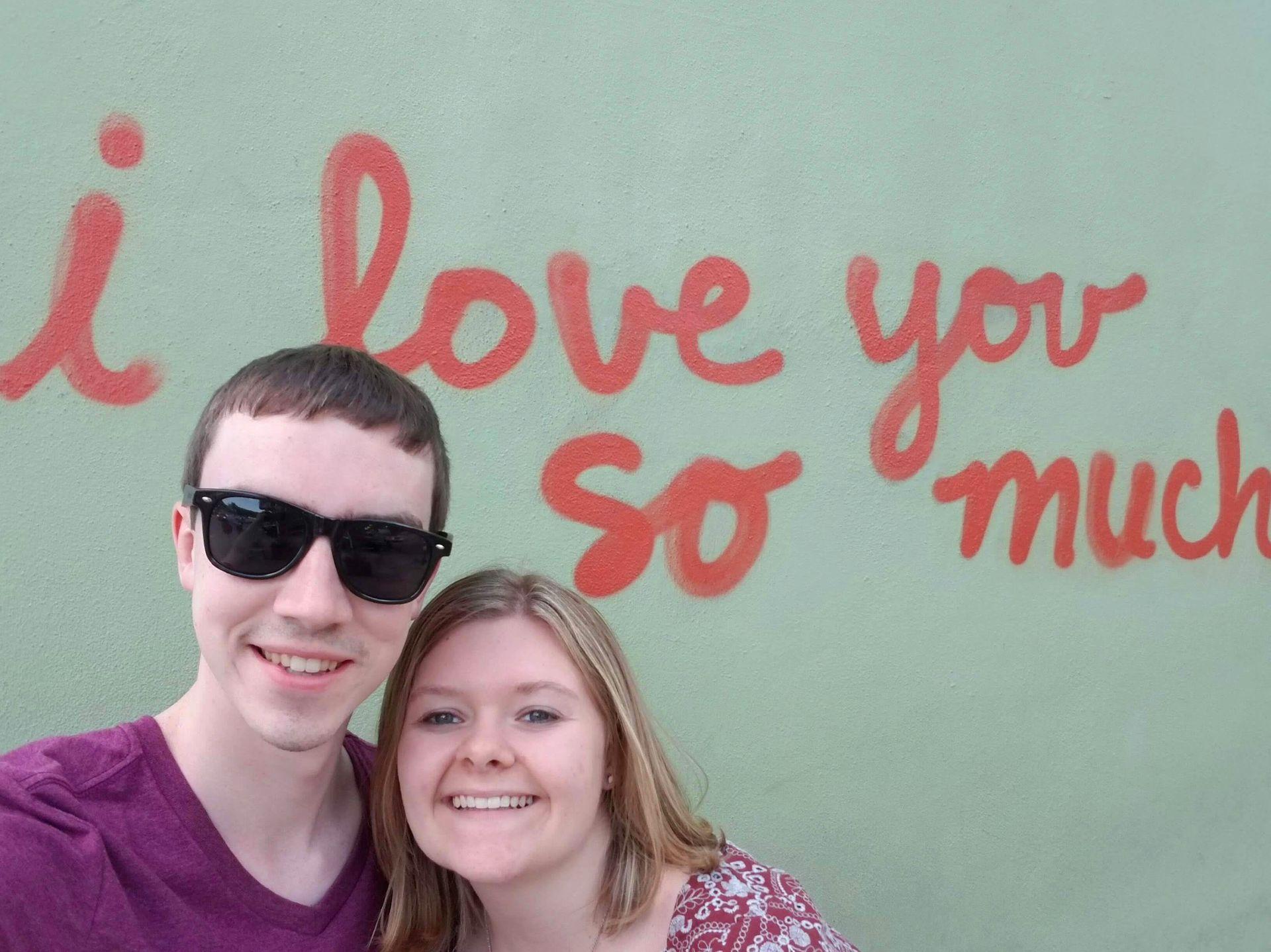Lydia and Joe in front of the "I Love you So Much" mural in SoCo, Austin.