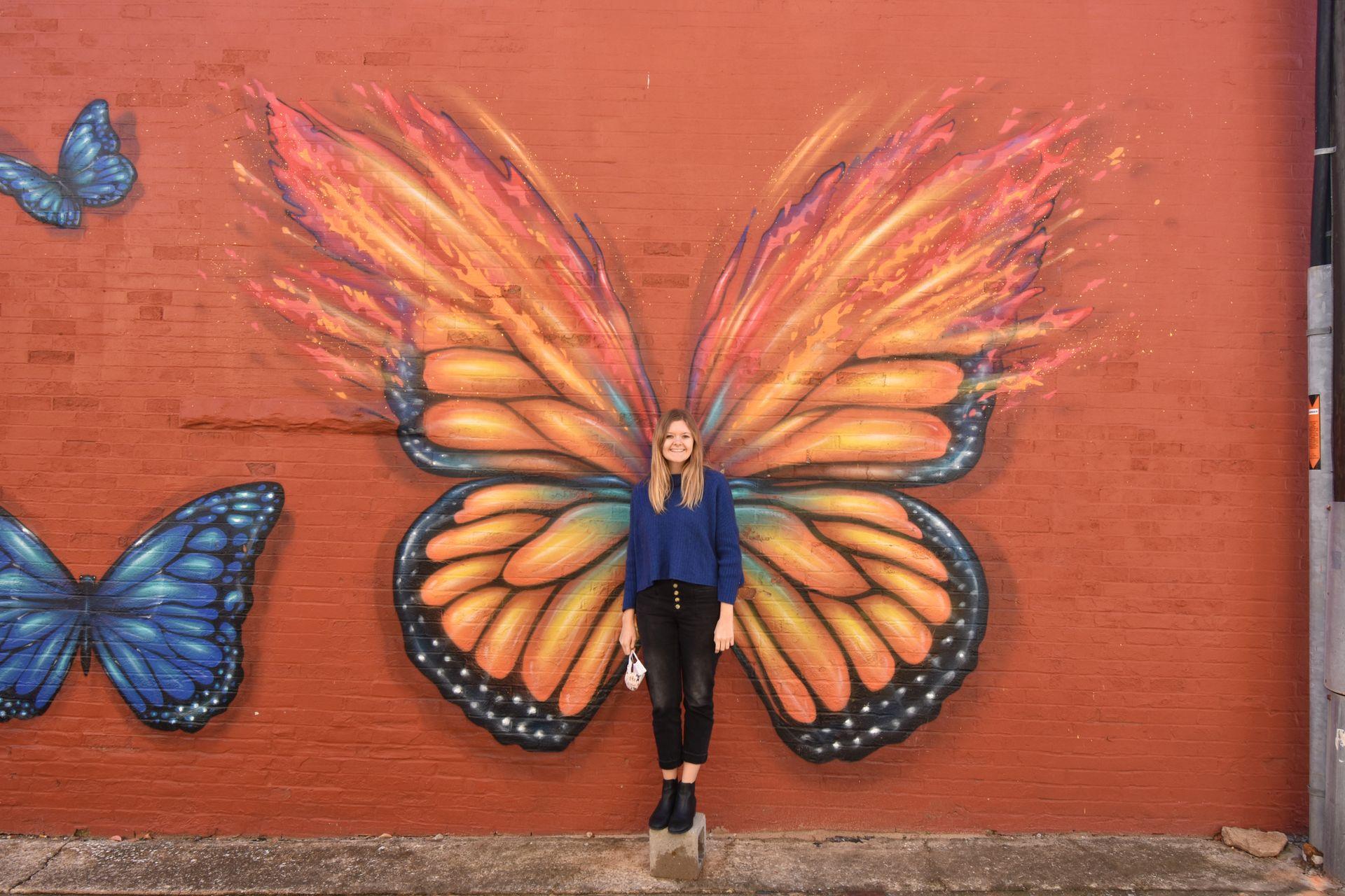 Lydia standing in front of the butterfly mural in Denison, Texas