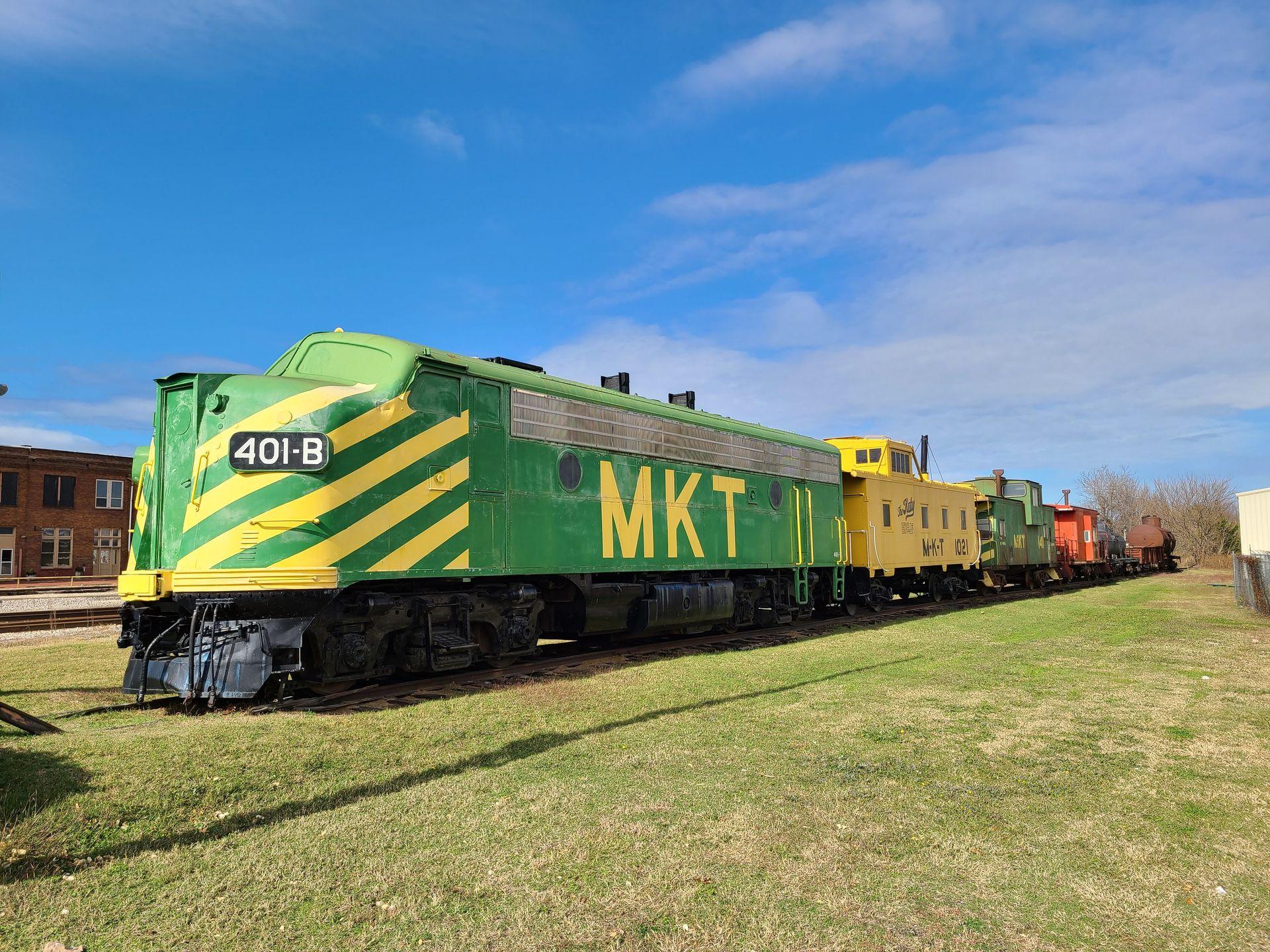 A green and yellow train at the Katy Depot.
