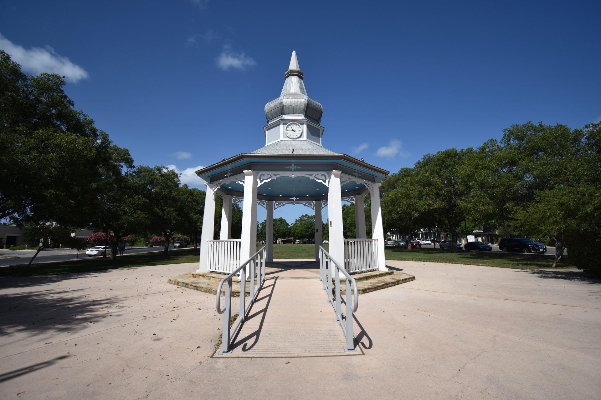 A small white gazebo in Main Plaza Park. The roof of the gazebo is blue.