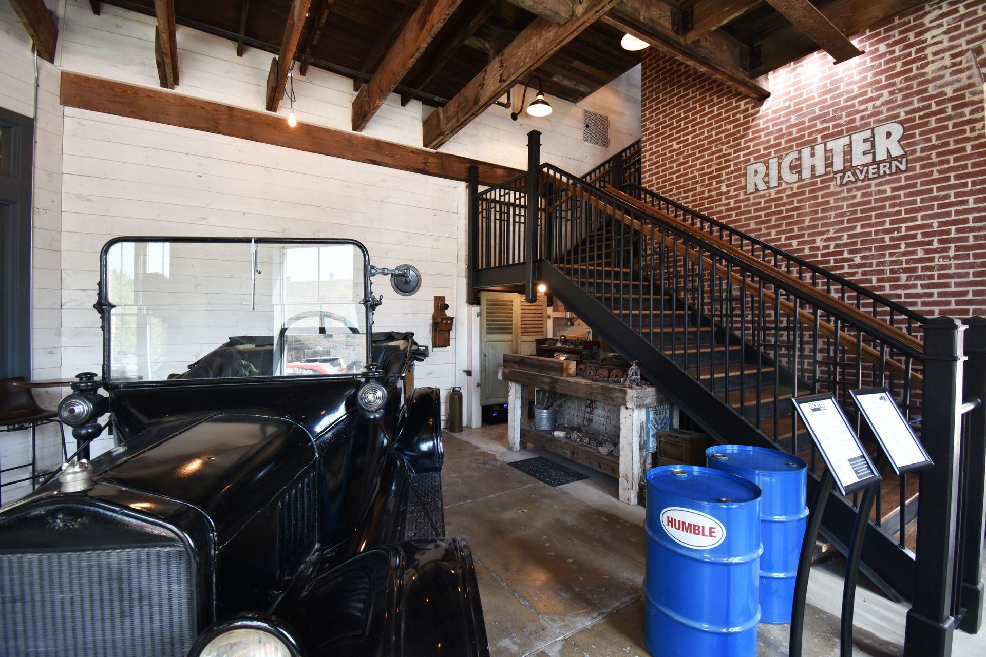 A vintage black car and a staircase leading up to the Richter Tavern.
