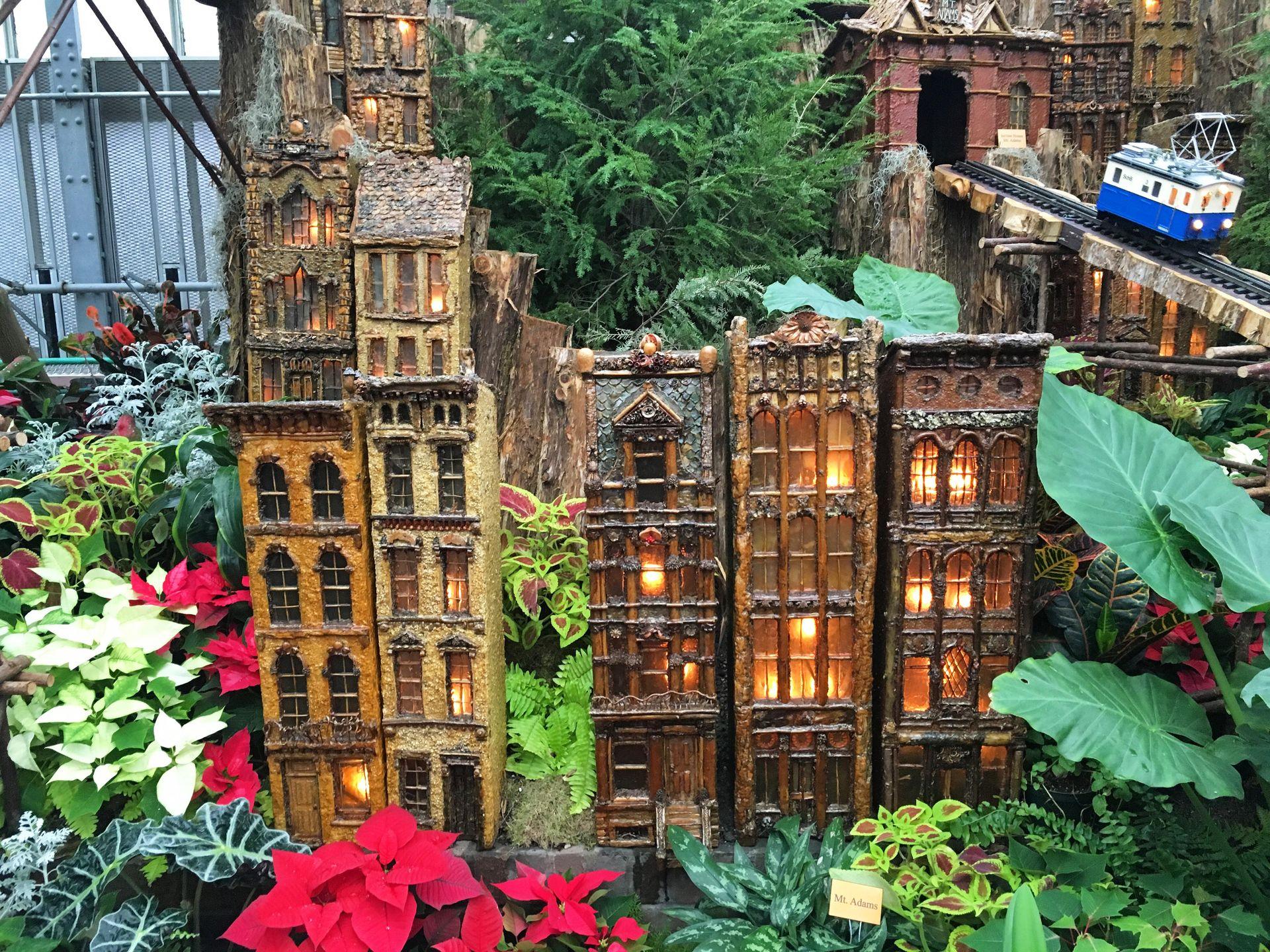 A Christmas display at the Krohn Conservatory that features tiny buildings among the plants.