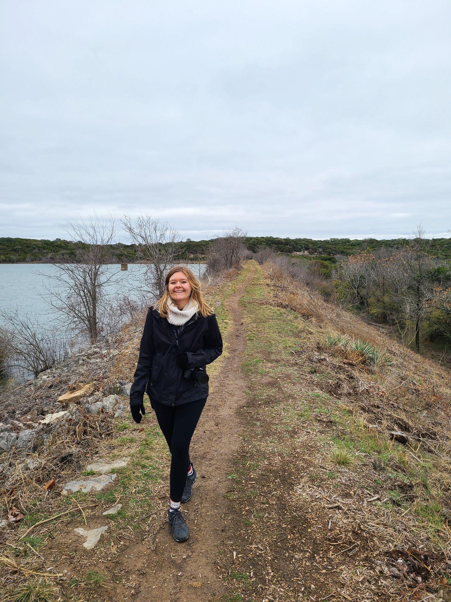 Lydia walking along a trail next to the lake in Cleburne State Park