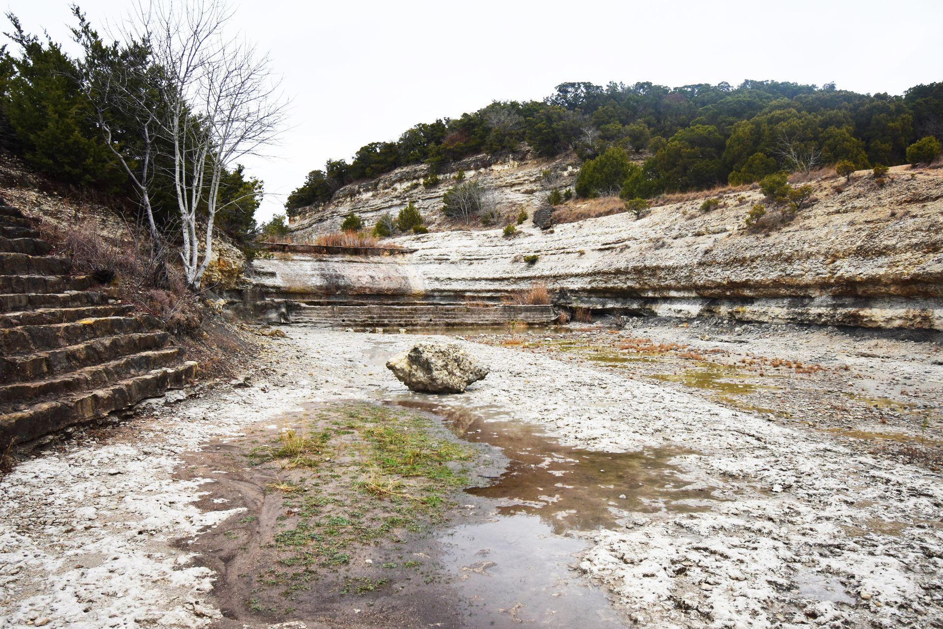 A large spillway area with a boulder in Cleburne State Park.