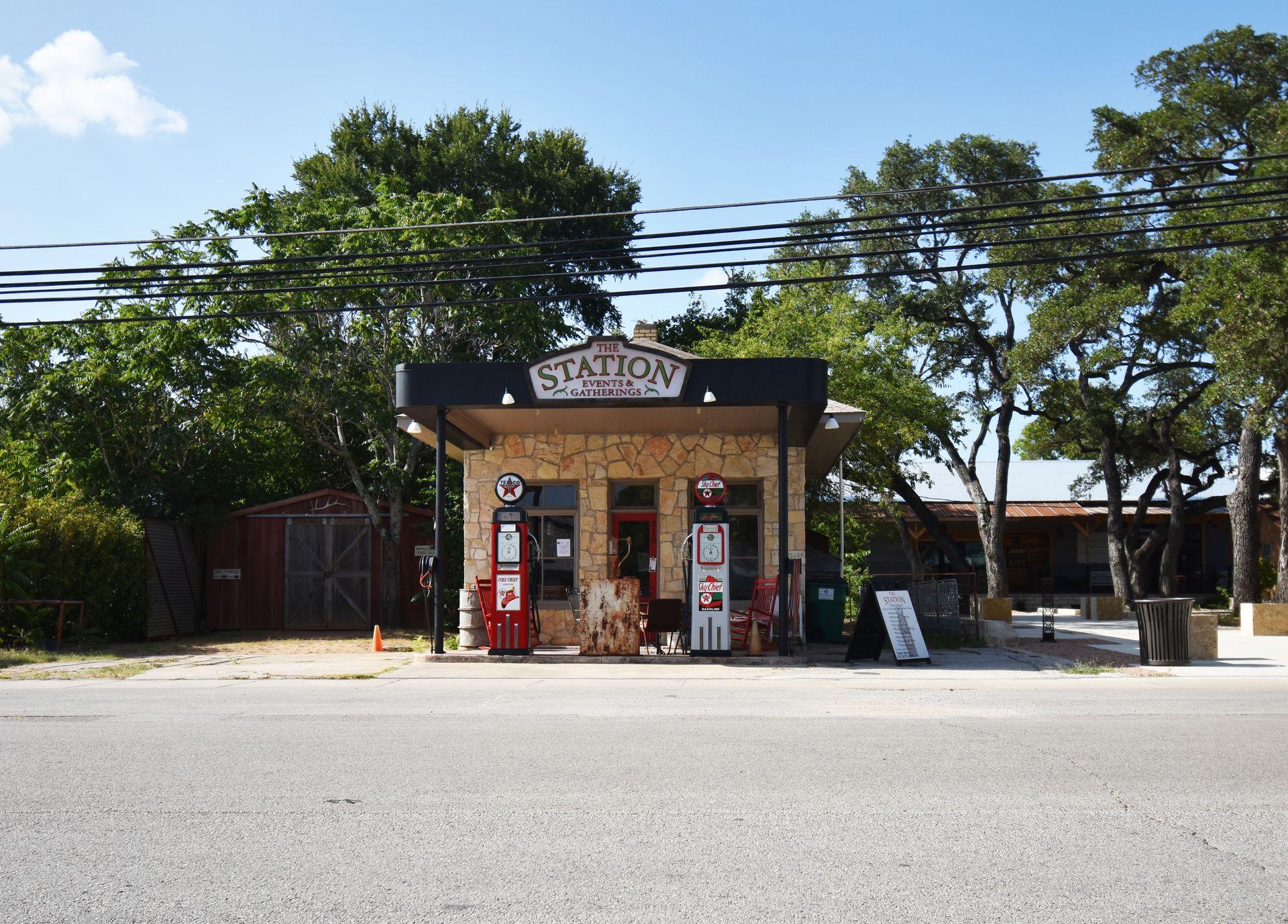A vintage looking gas station that has a sign for "The Station: Events & Gatherings"