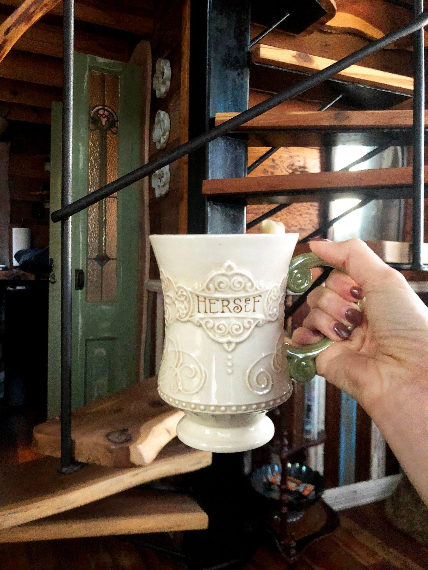 Holding up a regal mug inside of Havenwald.