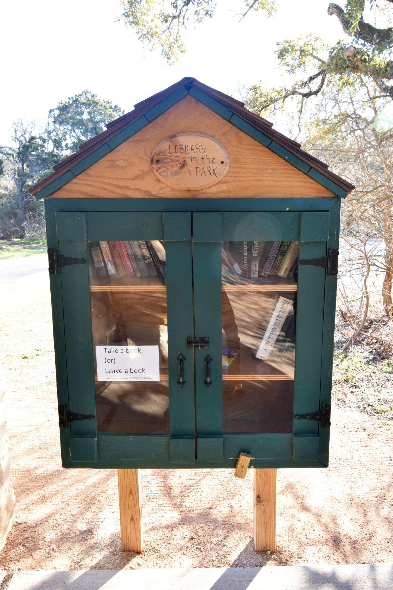 A green cabinet with books to borrow and exchange at the Mother Neff campground
