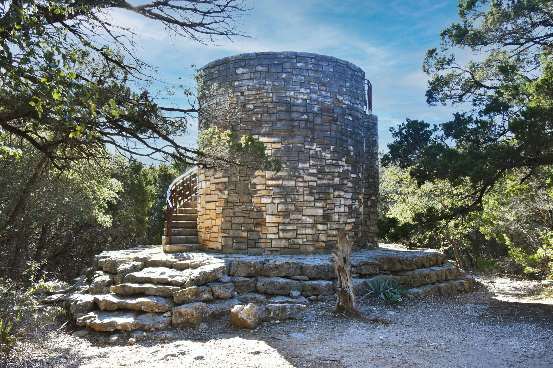 A round tower made of brick with a staircase spiraling around it.