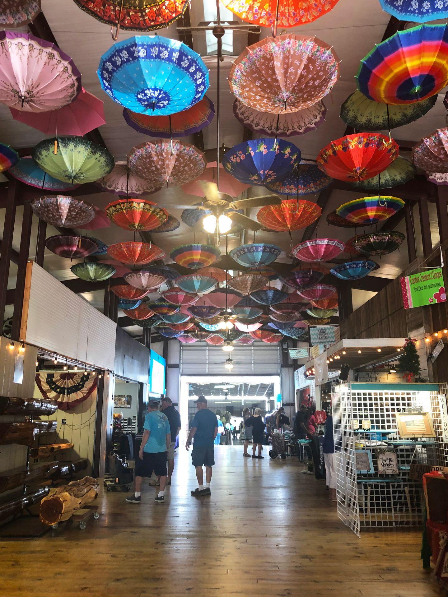 A market hall room with colorful umbrellas hanging from the ceiling.