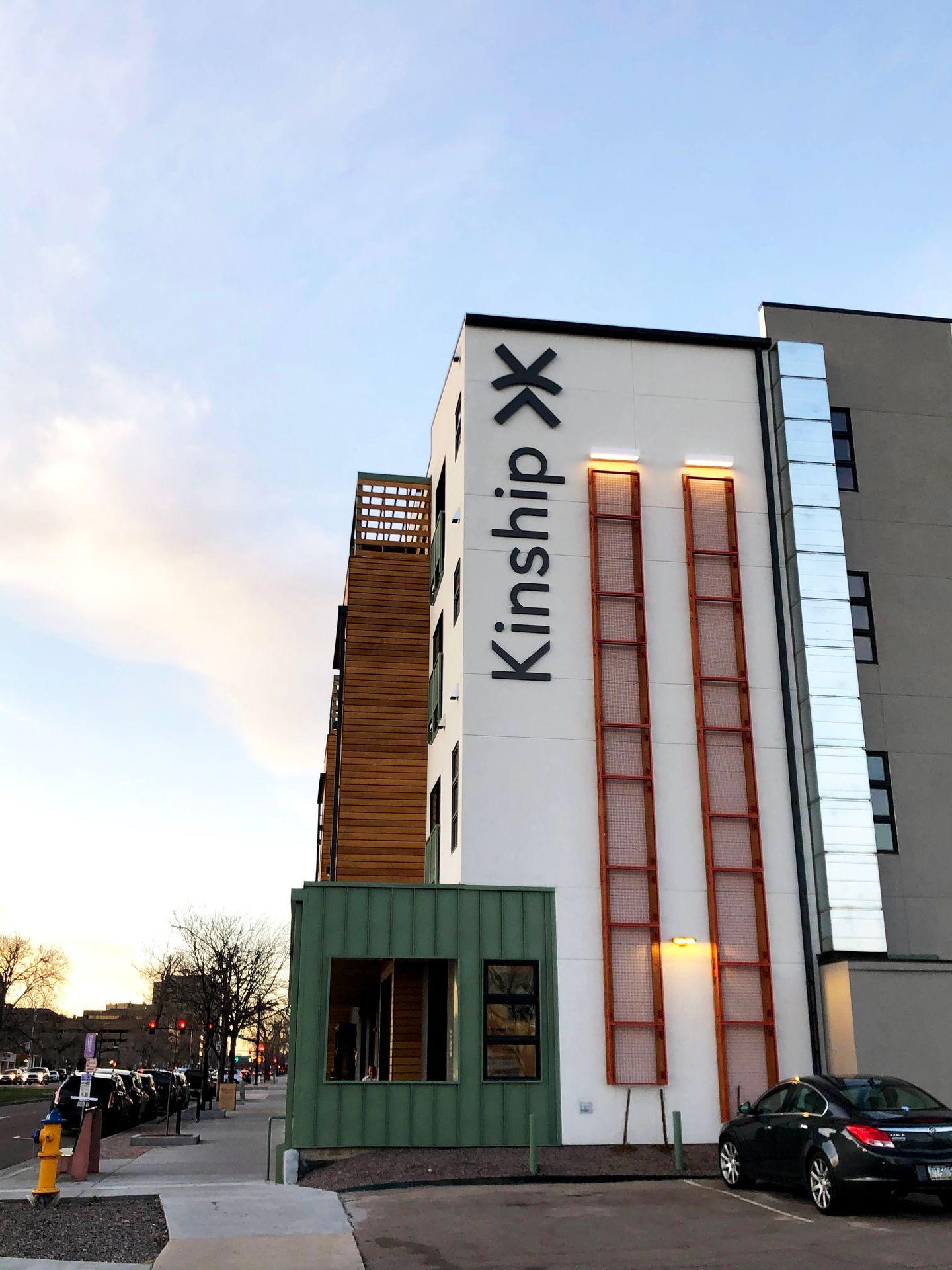 The Kinship Landing Hotel from the outside. The building is several stories tall and says "Kinship"