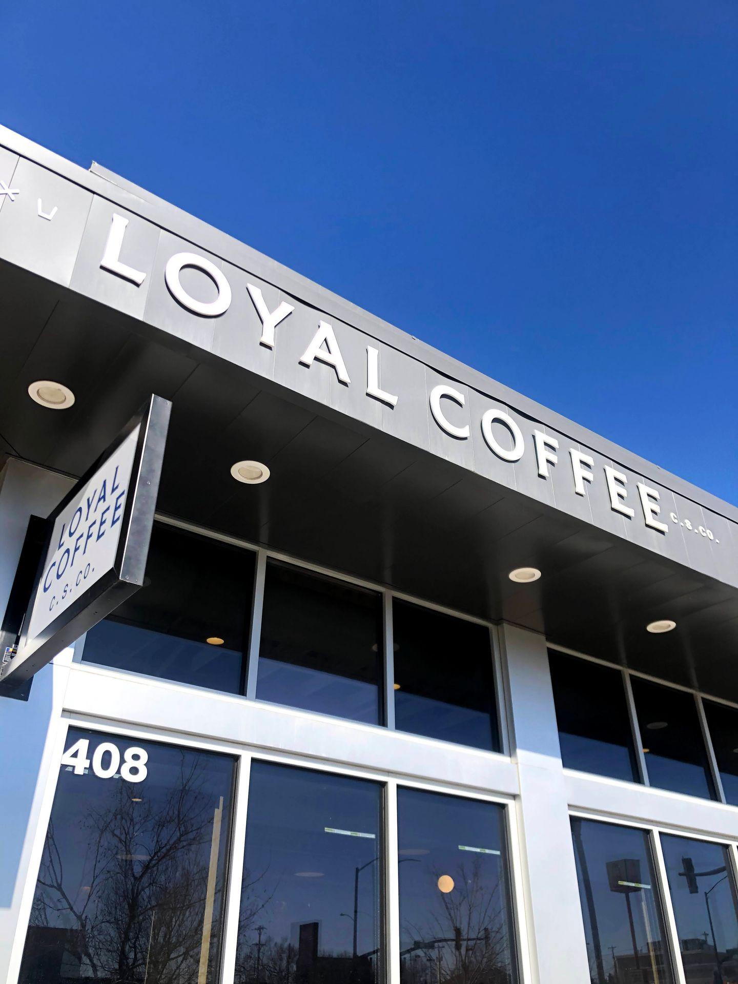 The exterior of Loyal Coffee. The building is gray with white letters.