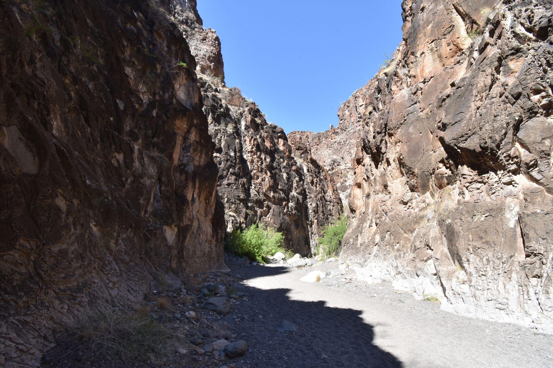 A wide trail with canyon walls towering up on each side.