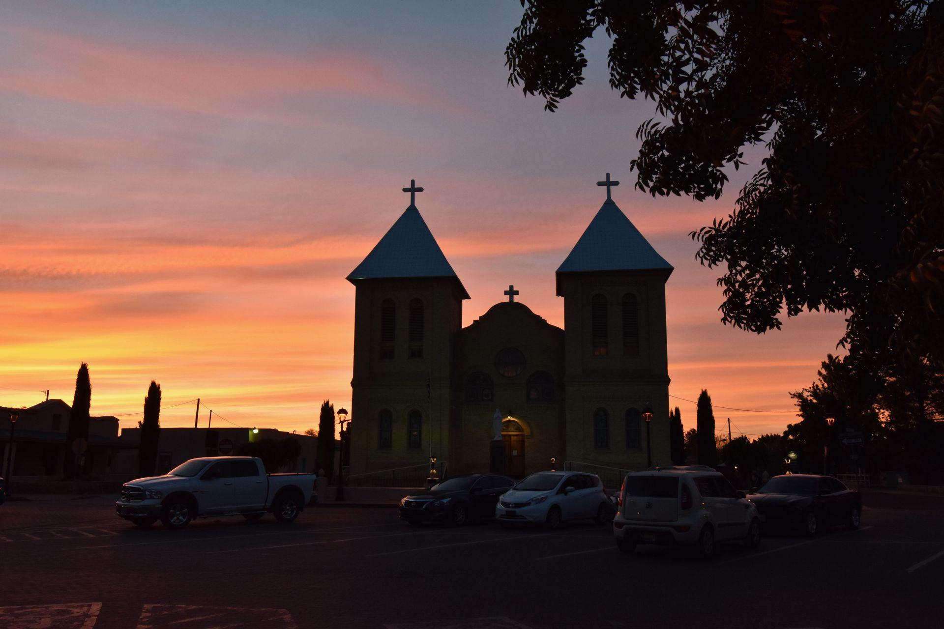 The silhouette of a church with a sunset behind it at Old Mesilla Square.