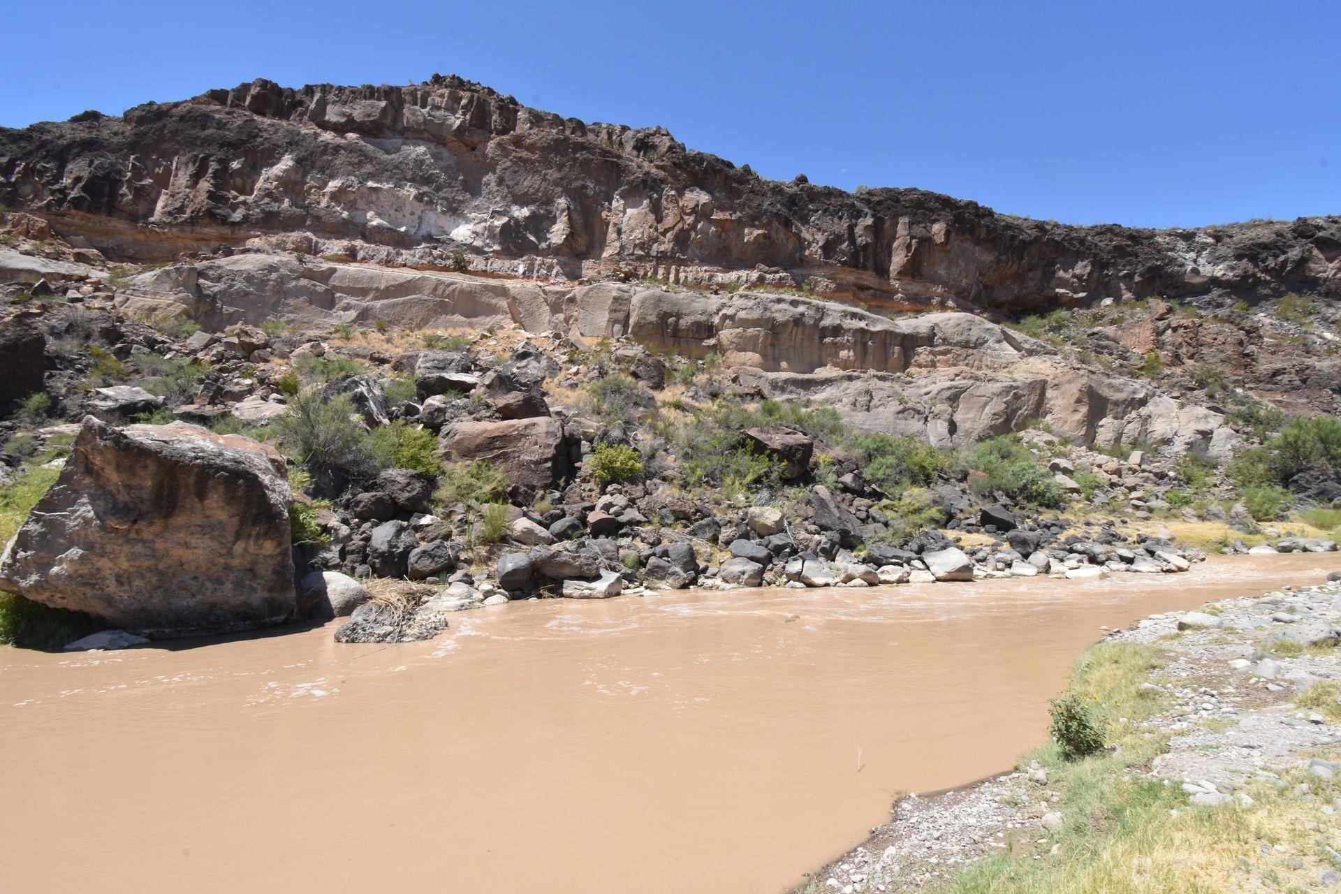 The Rio Grande river with a mountain on the other side of the river.