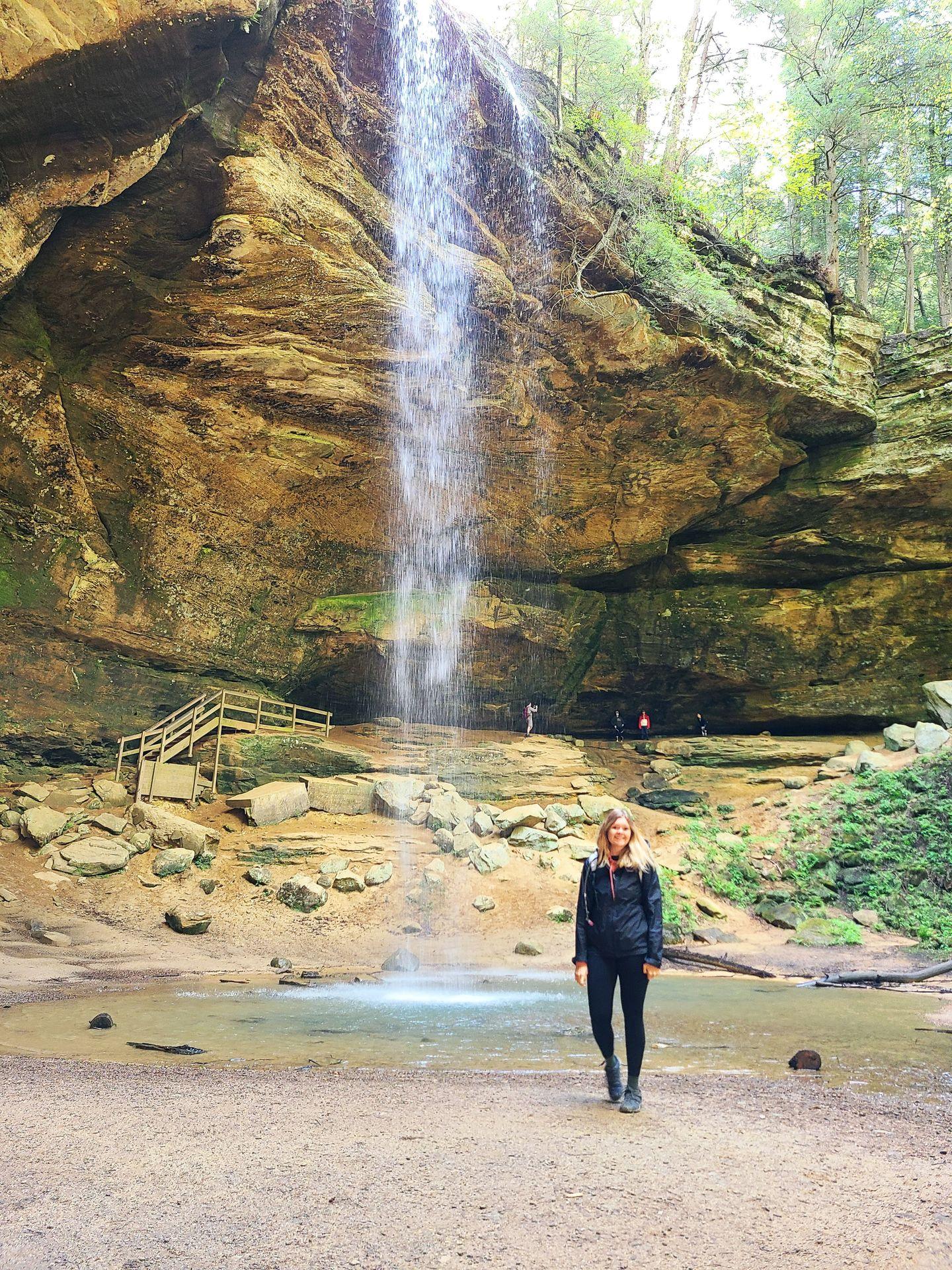 Lydia standing in front of the Ash Cave waterfall.