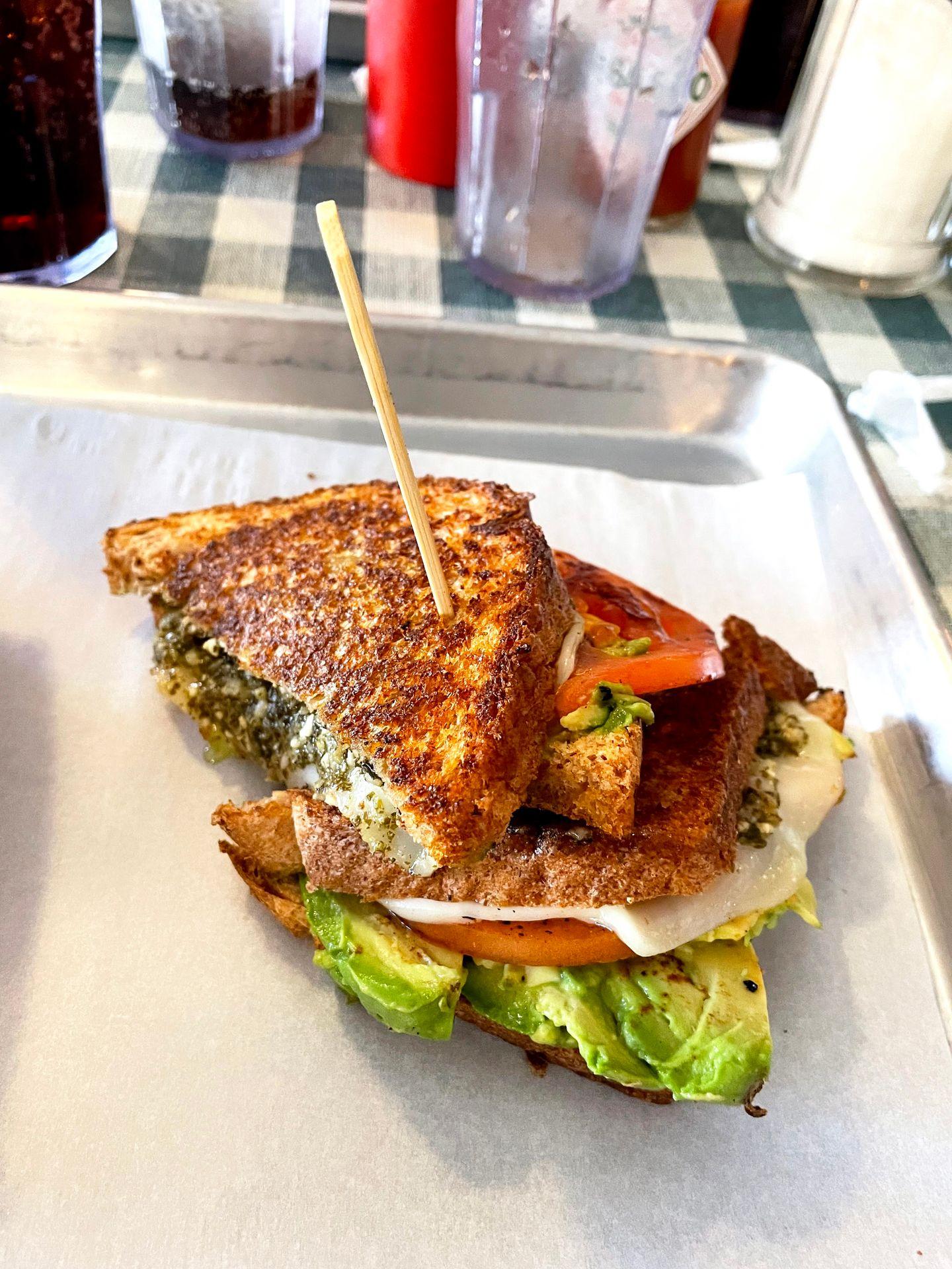 A sandwich with avocado, tomato, pesto and cheese from Wimberley Cafe
