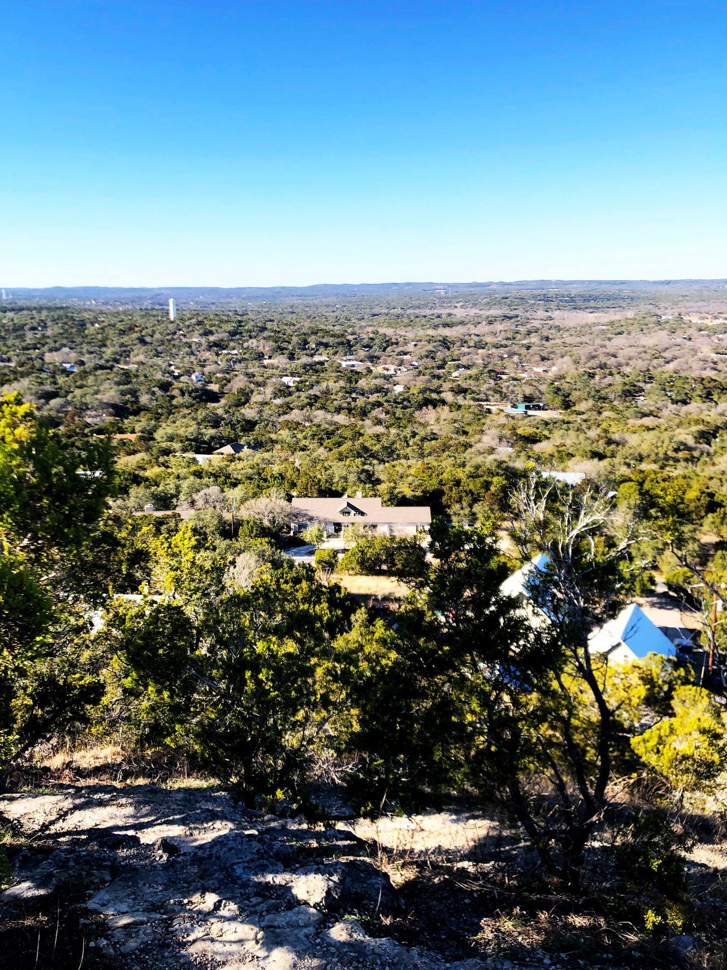 The view of Wimberley from Old Baldy. You can see a lot of trees and some houses.