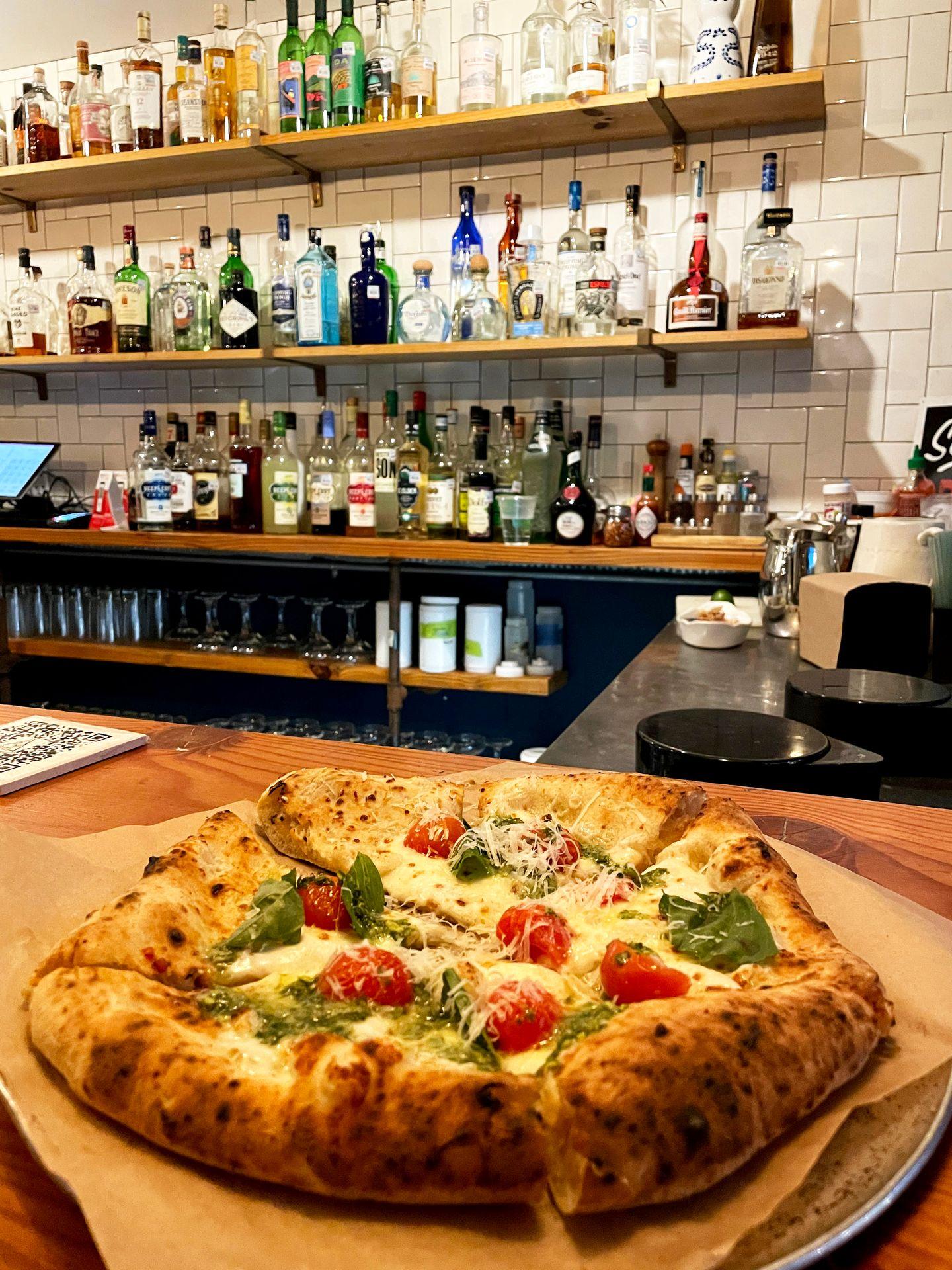 A small pizza topped with cherry tomatoes at Community Pizza and Beer Garden.