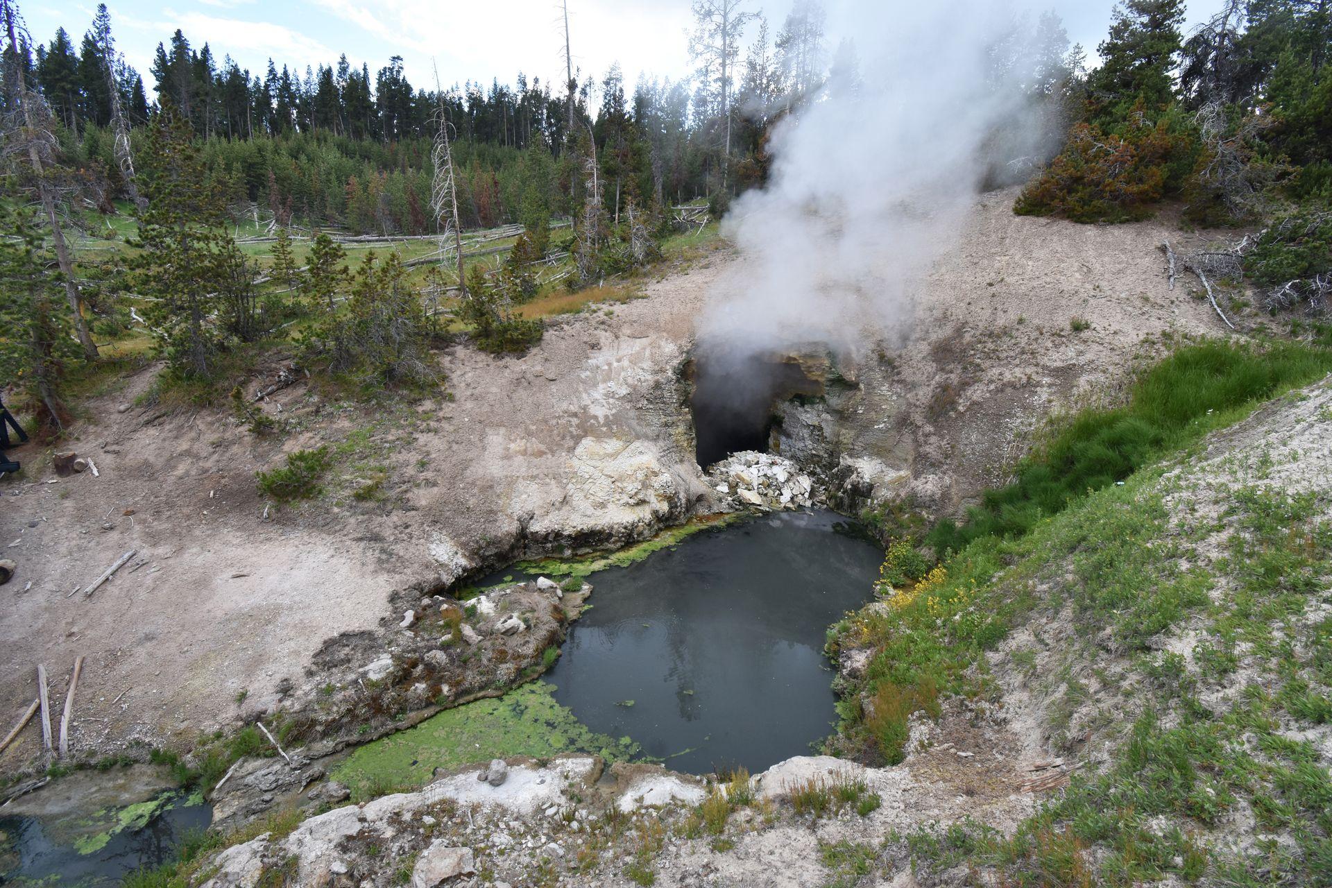 Steam rising from a little cave next to a hot spring at the Mud Volcanoes area.