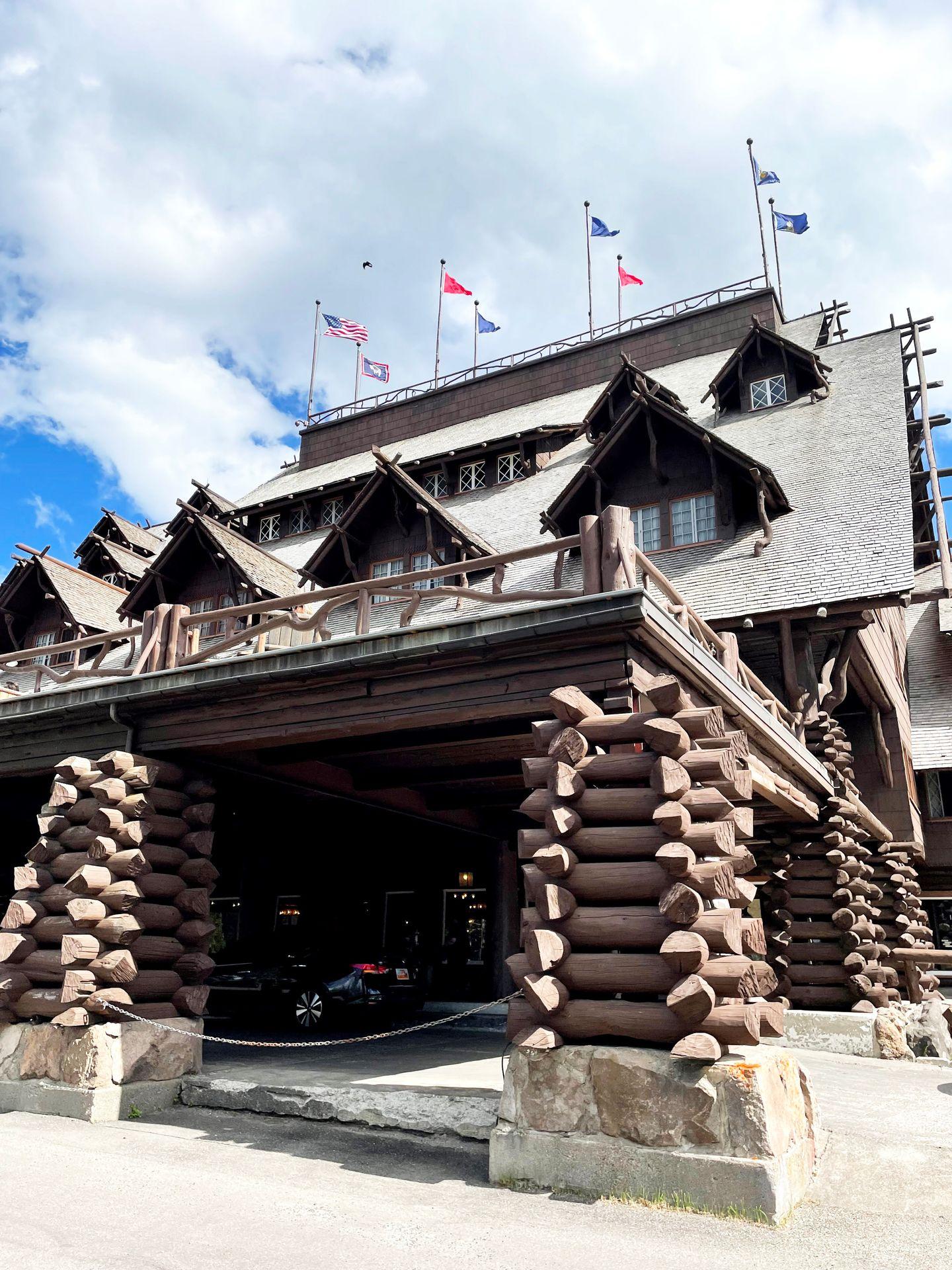 The exterior of Old Faithful Inn which is made up of stacked logs.