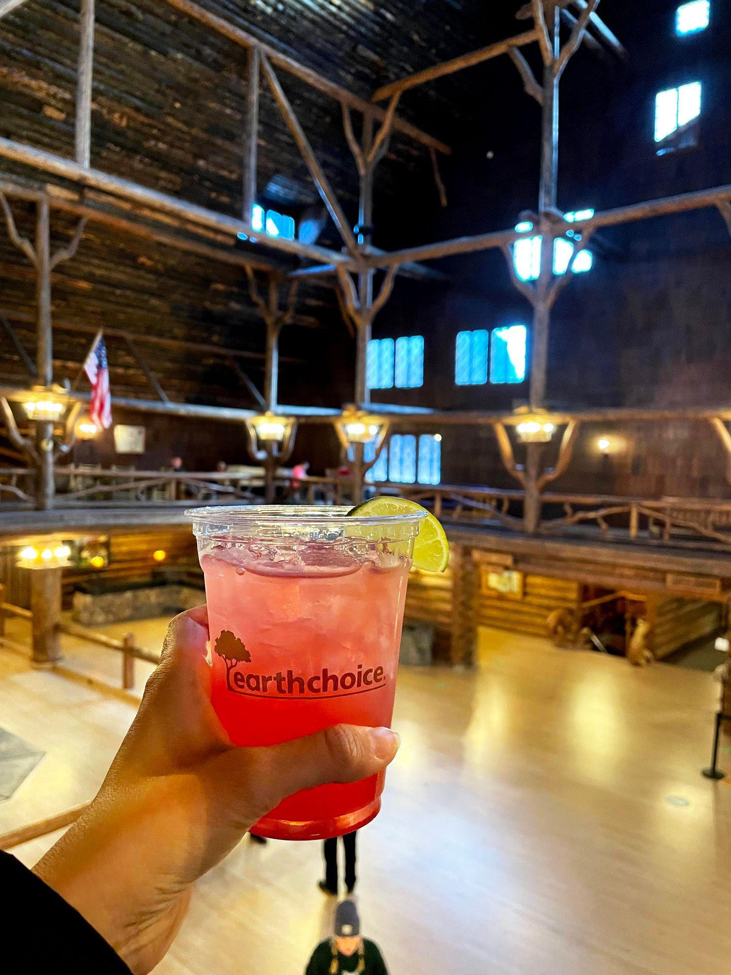 Holding up a cocktail in the lobby of the Old Faithful Inn