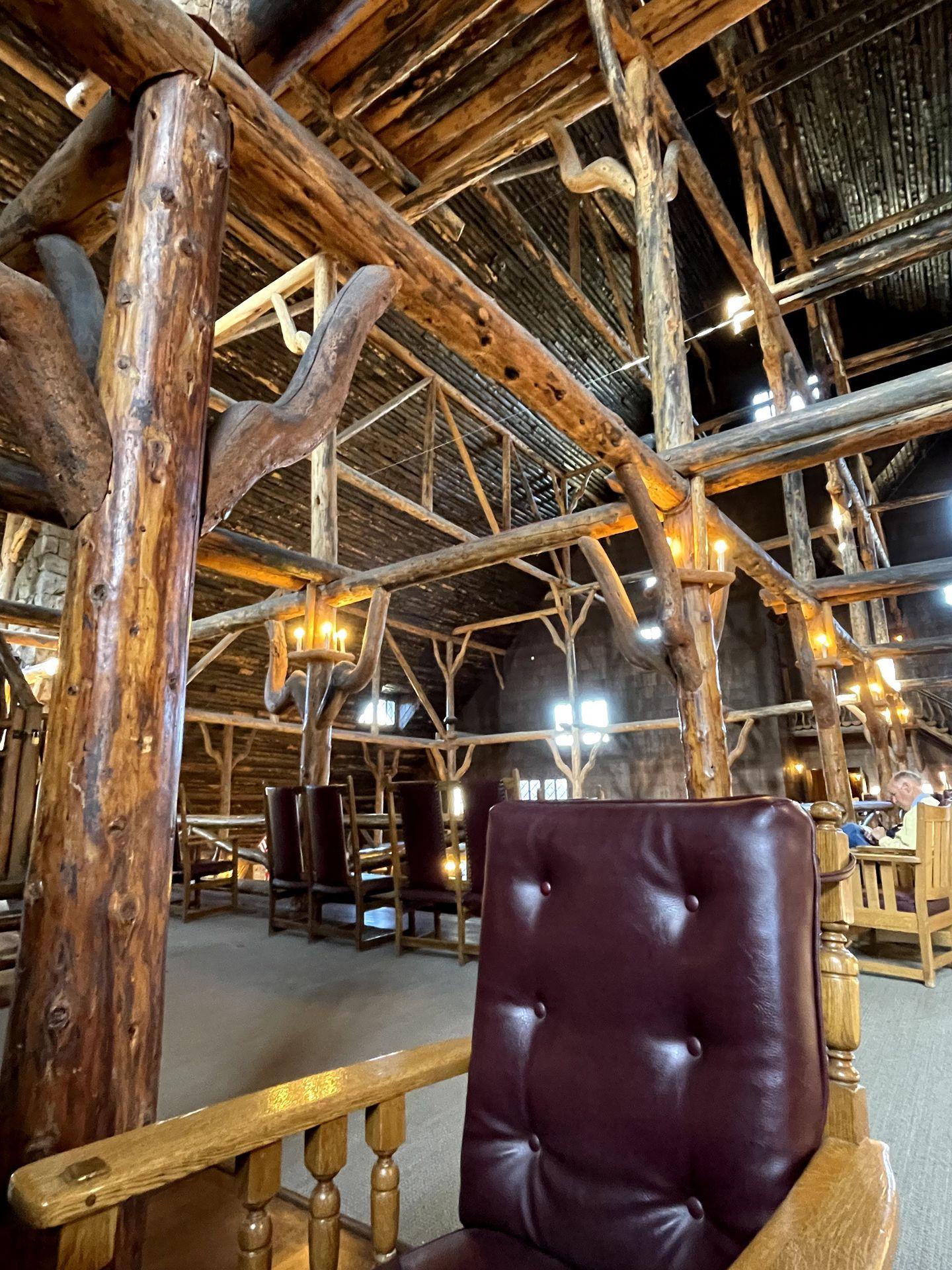 A chair and the ceiling made up of logs in the lobby of the Old Faithful Inn