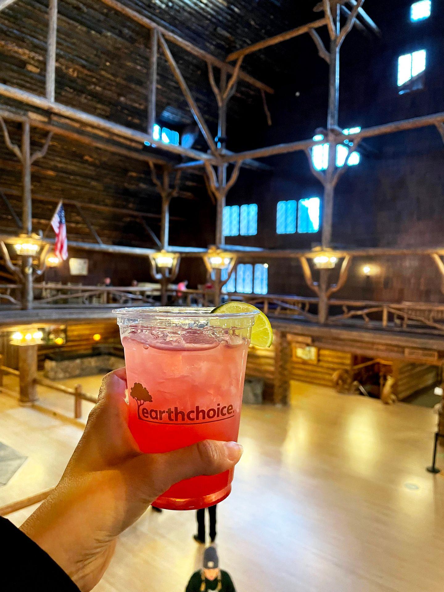 Holding up a cocktail inside of the Old Faithful Inn.