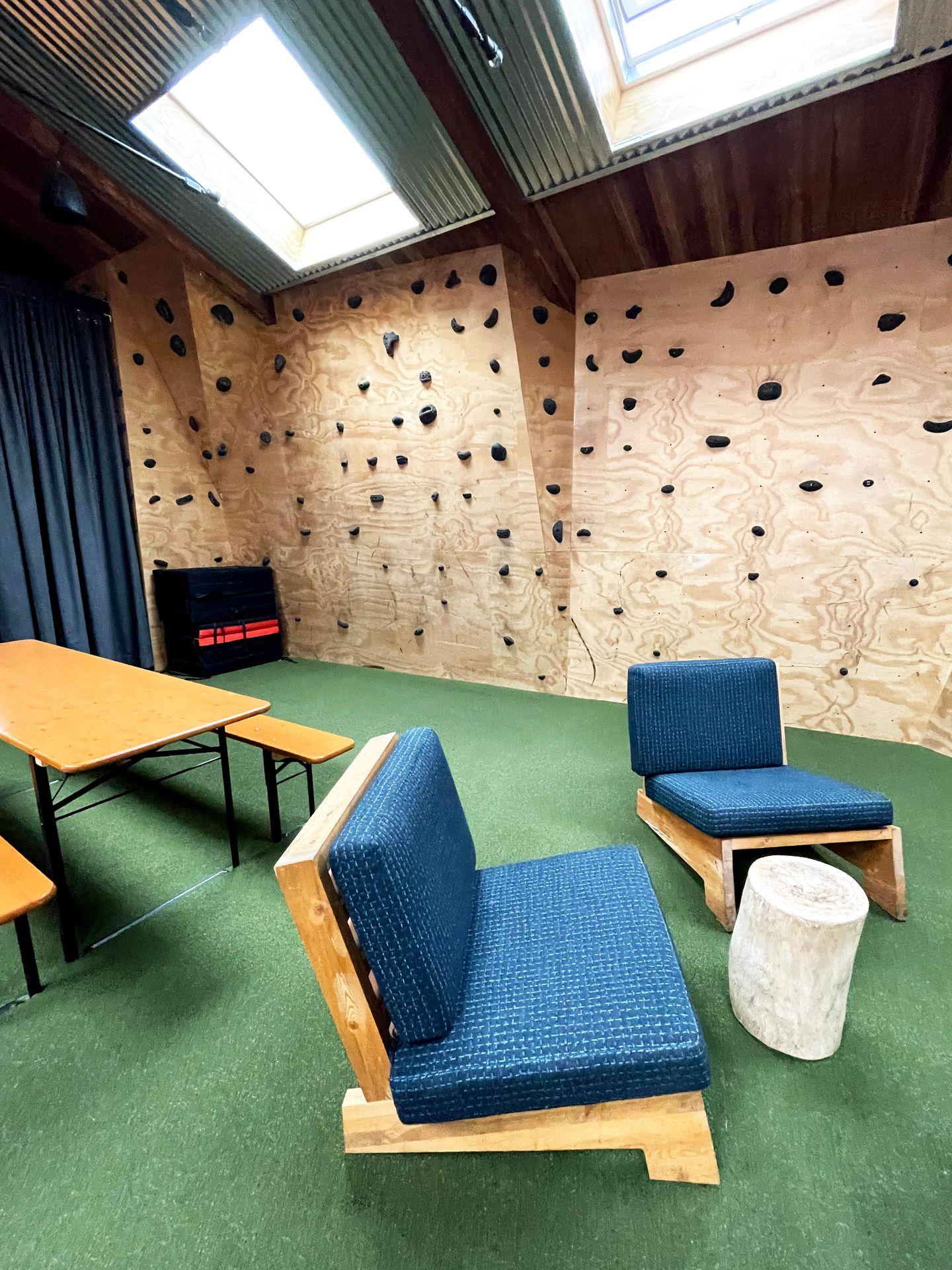 A lobby area of Basecamp Boulder with a rock climbing wall.