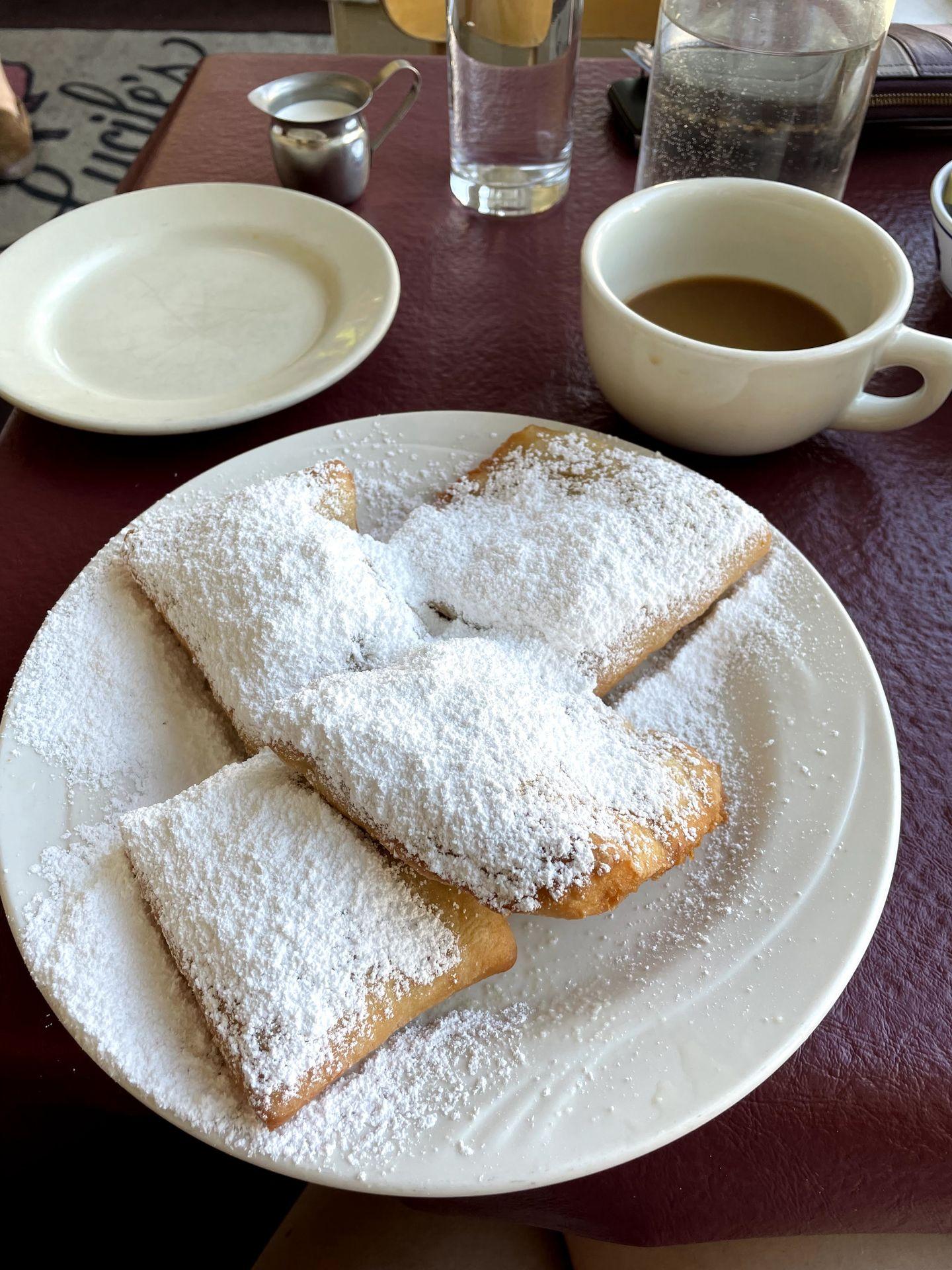 A plate of beighnets covered in powdered sugar from Lucile's Creole Cafe