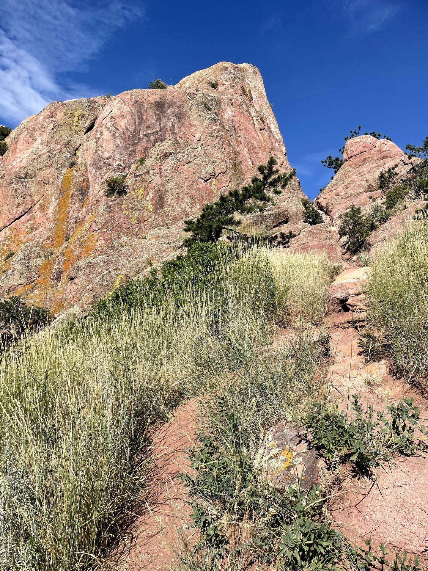 A path leading up to some large, red rocks.