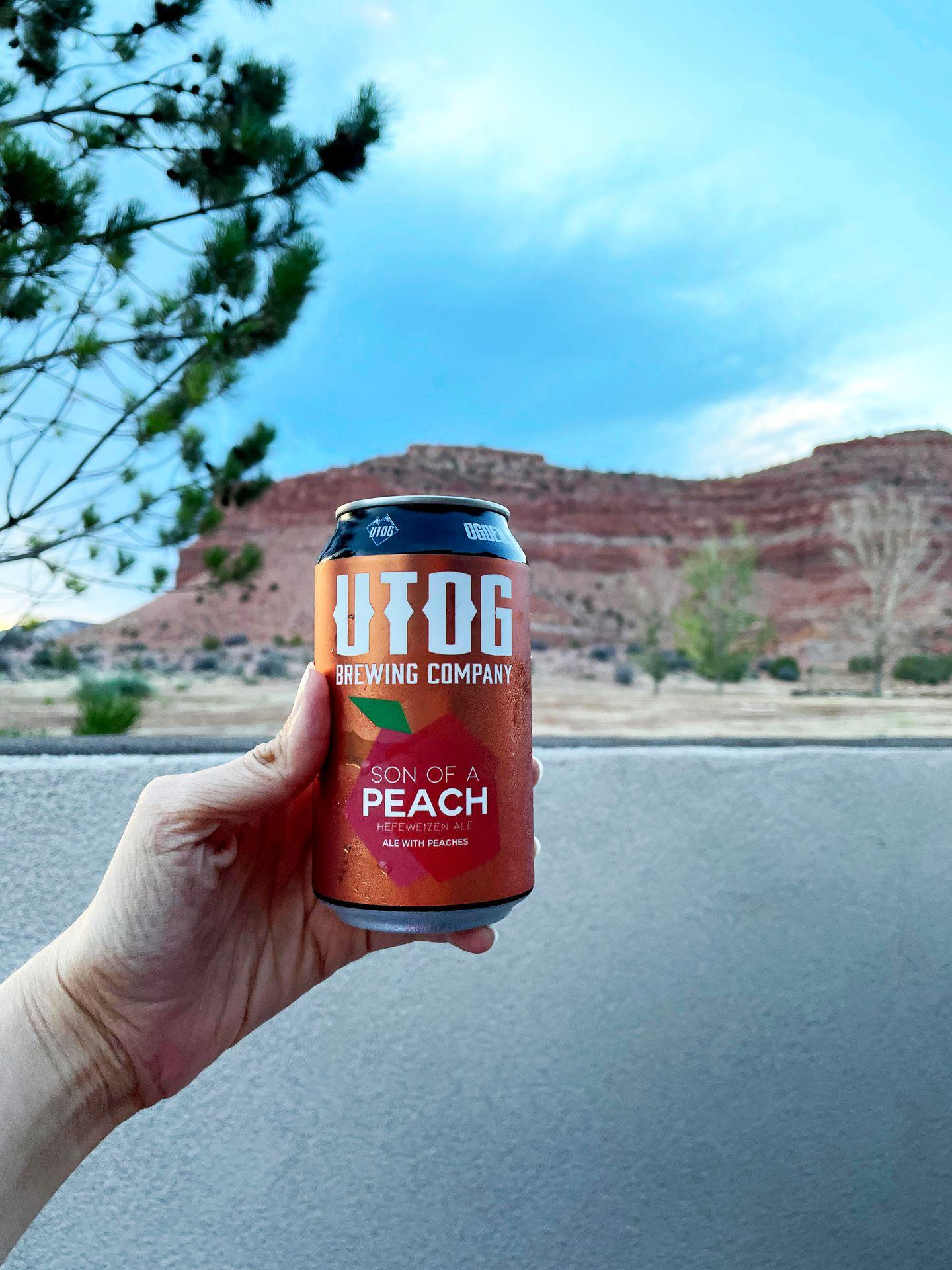 Holding up a local Utah beer with orange rocks in the background.