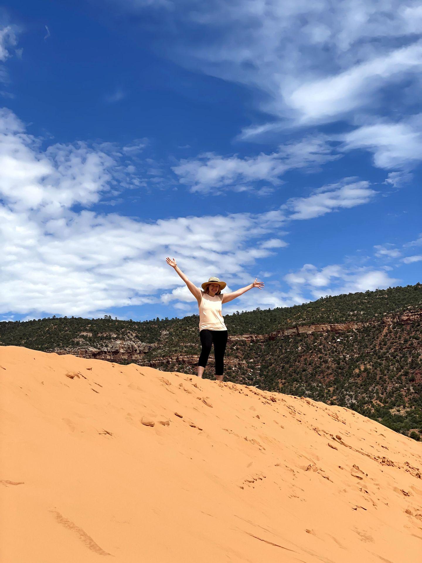 Lydia on top of a sand dune at Coral Pink Sand Dunes State Park.
