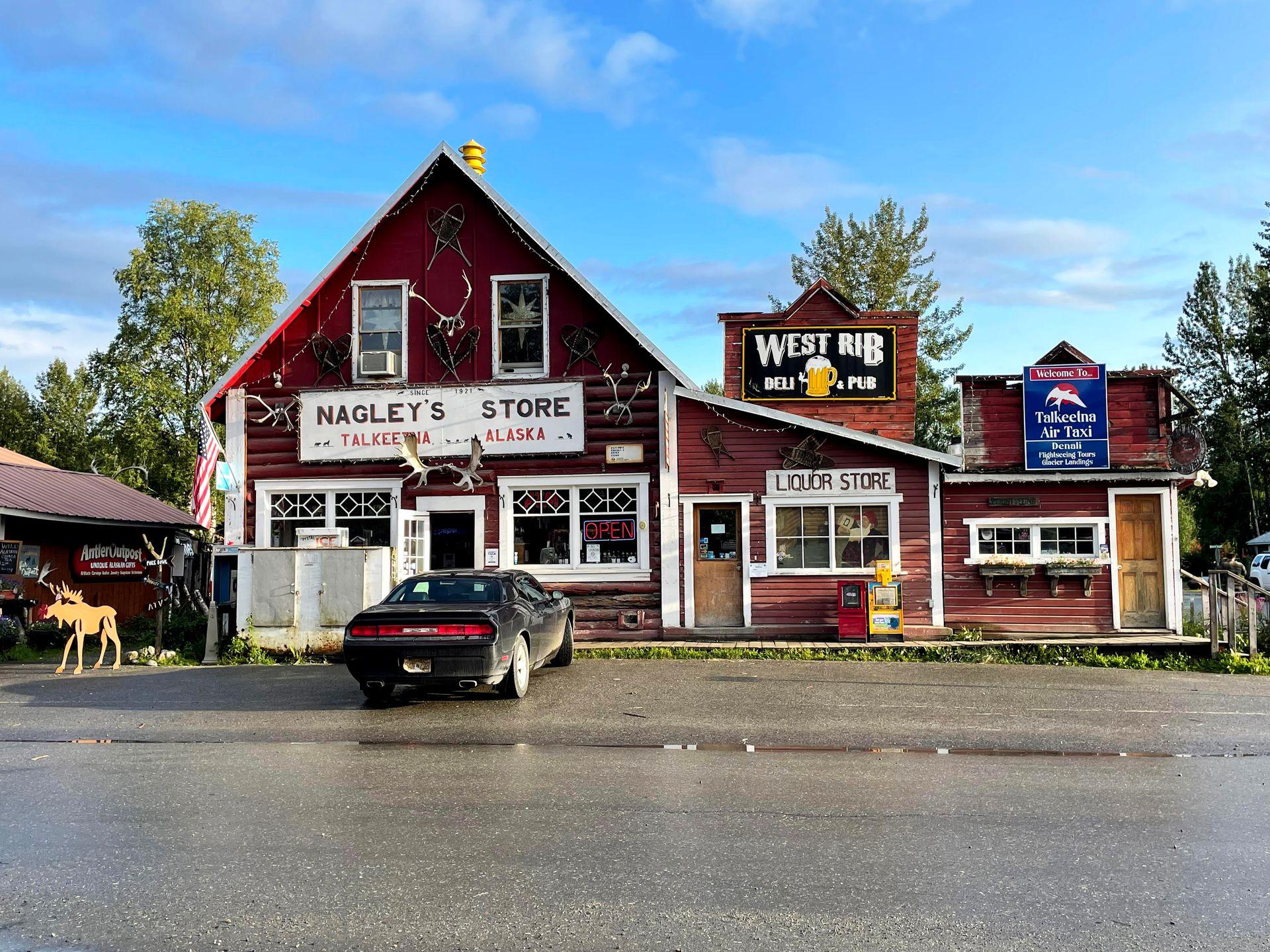 A view of Nagley's Store, a red building with white trim, in Talkeetna, Alaska.