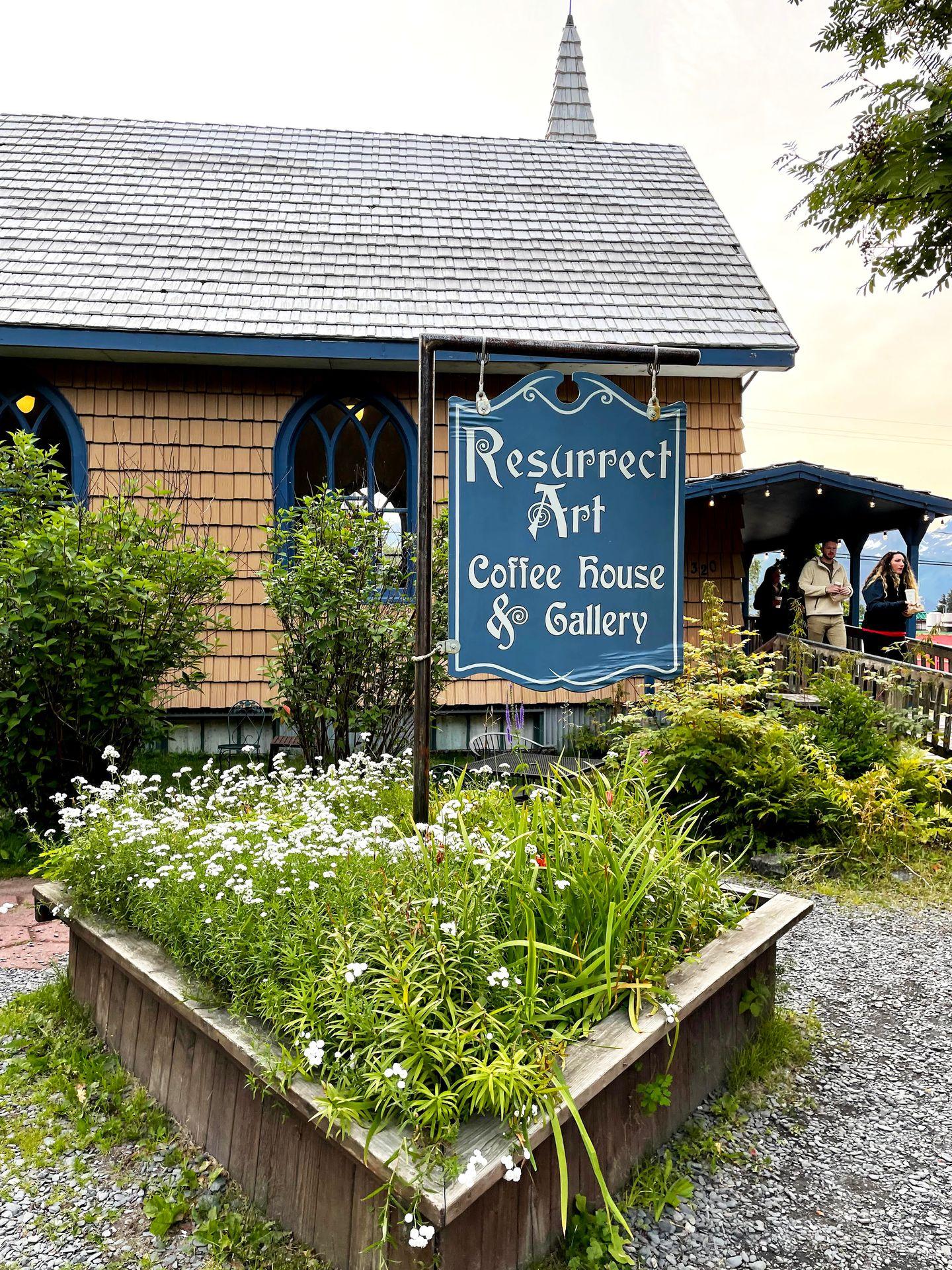 A blue sign outside of Resurrect Art Coffee House.