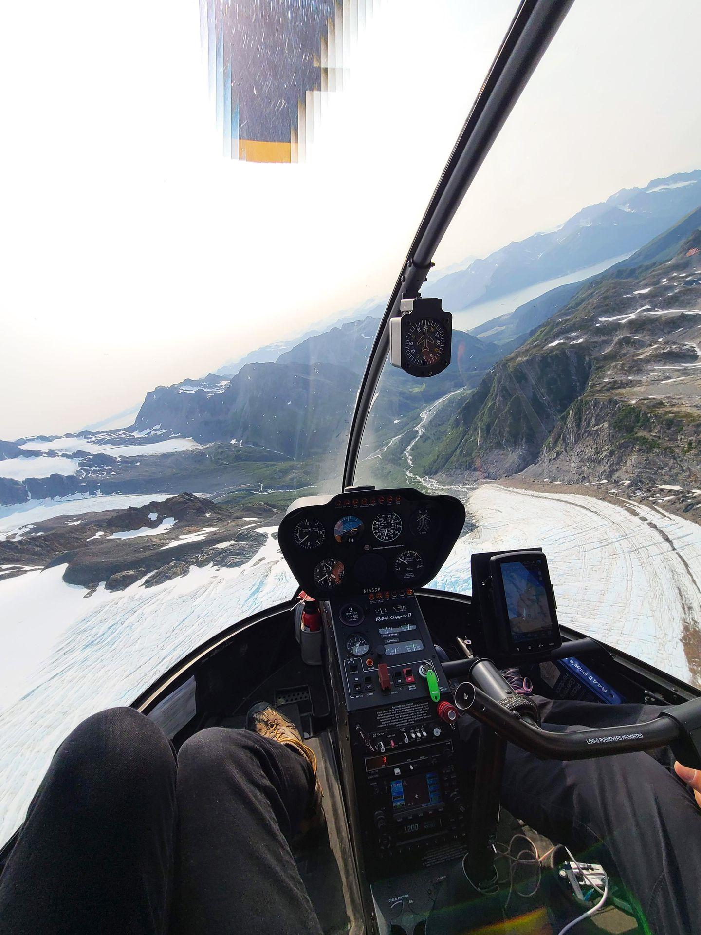 A view from inside a helicopter flying over snow and mountains near Seward.