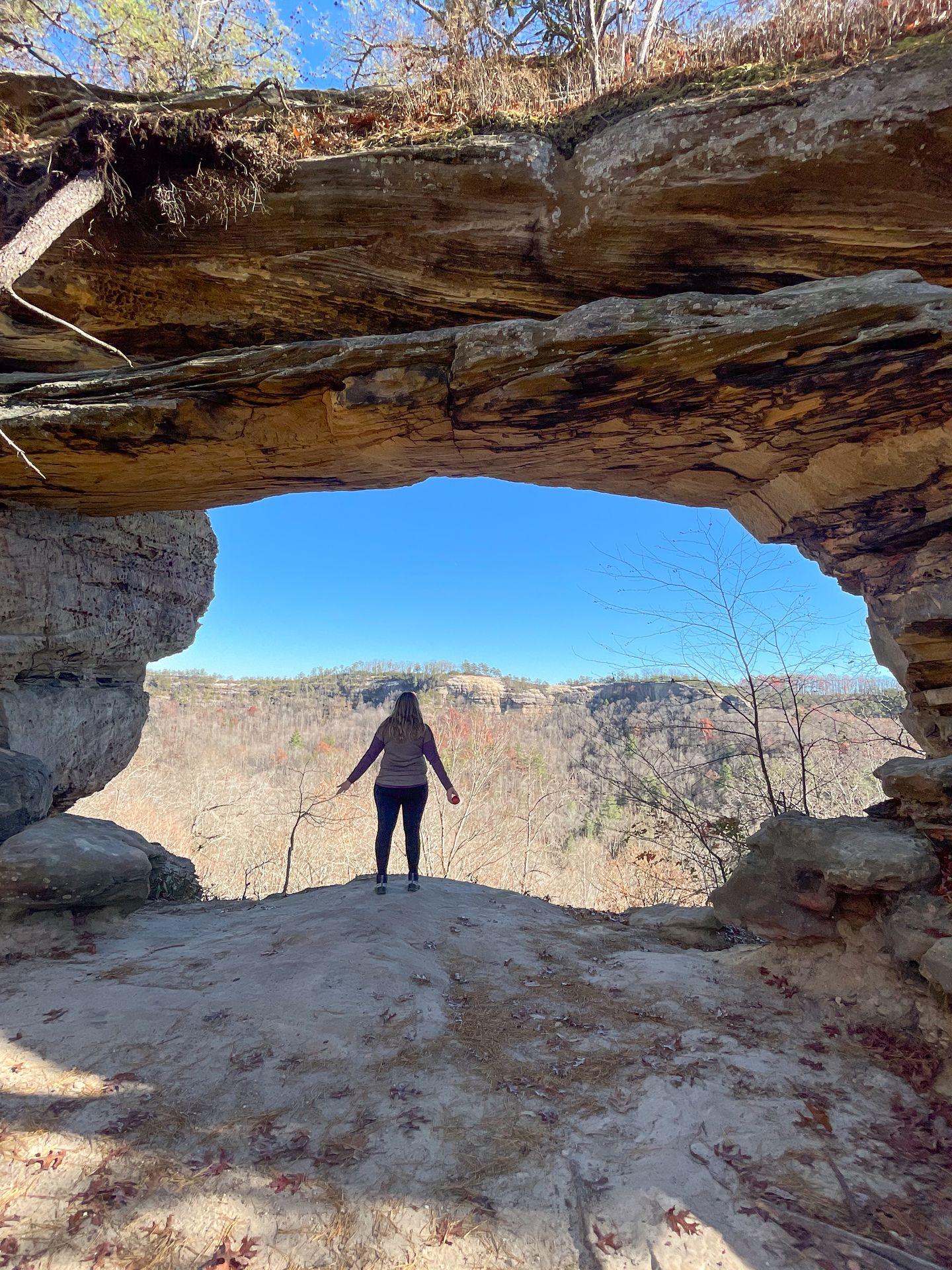 Lydia standing in the middle of Double Arch and looking out.