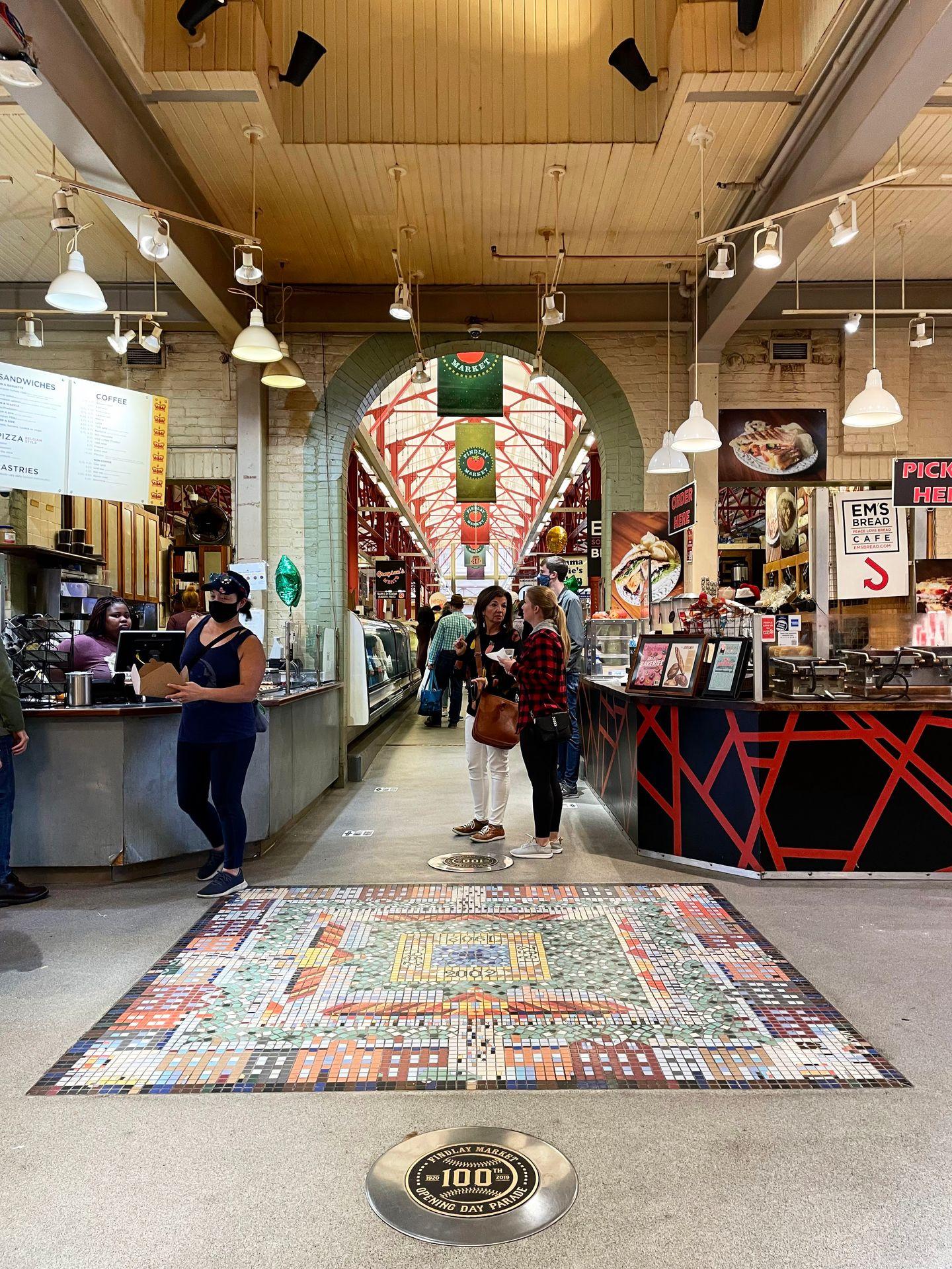 The interior of Findlay Market. There is a tile design on the floor in the center of the hall.