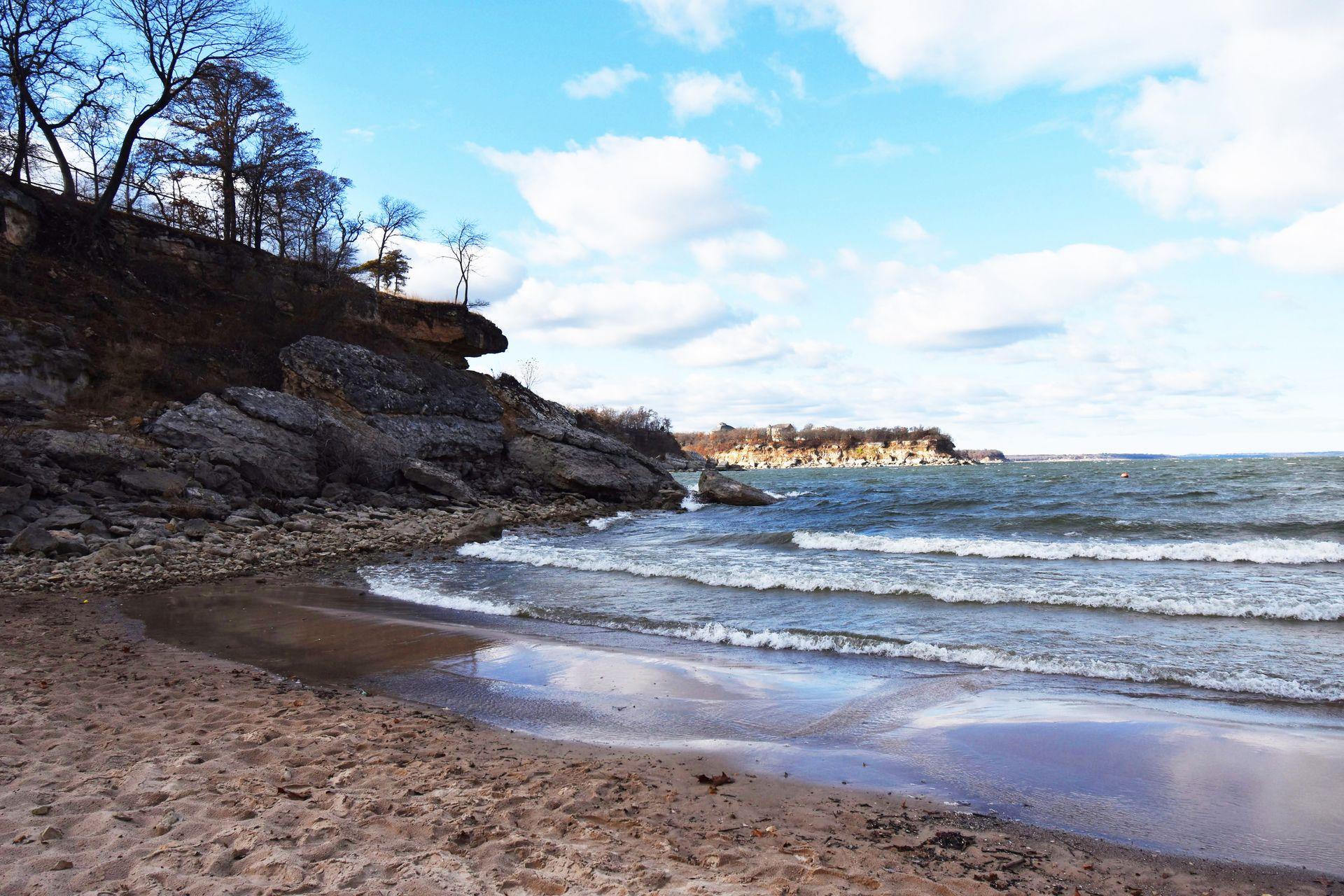 Standing on a beach with a cliff rising up at Eisenhower State Park.